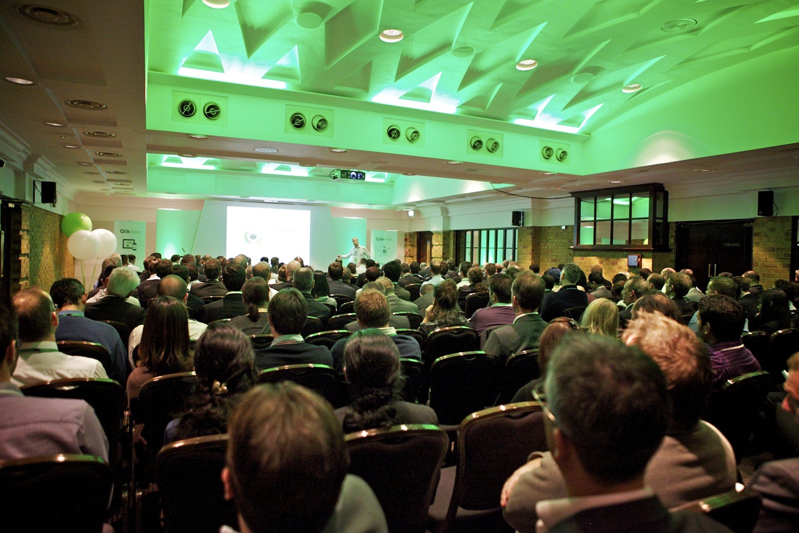 Conference at The Queen Charlotte with green lighting and theater seating for networking.
