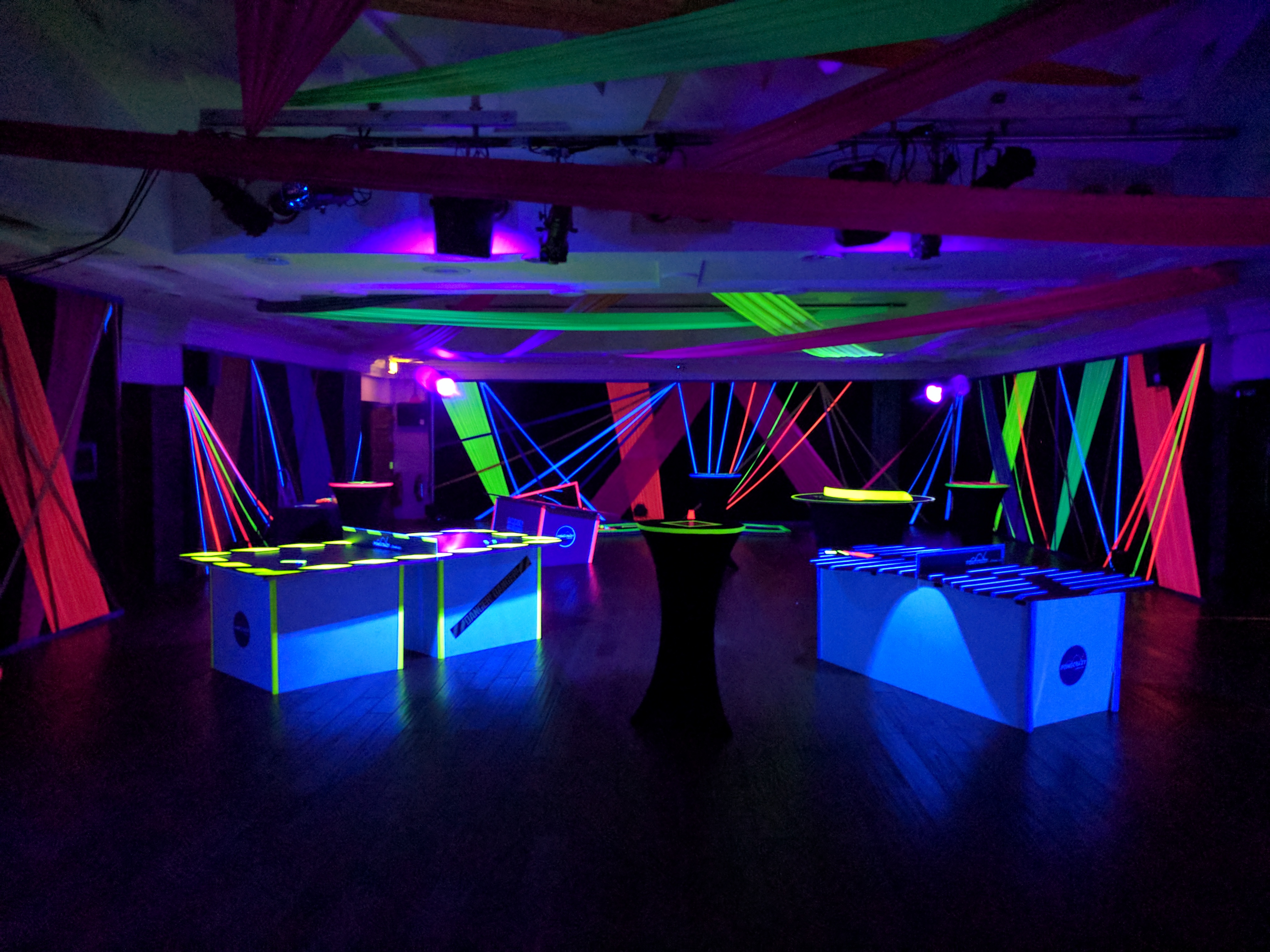 Vibrant event space at The Queen Charlotte with neon lighting for modern parties.
