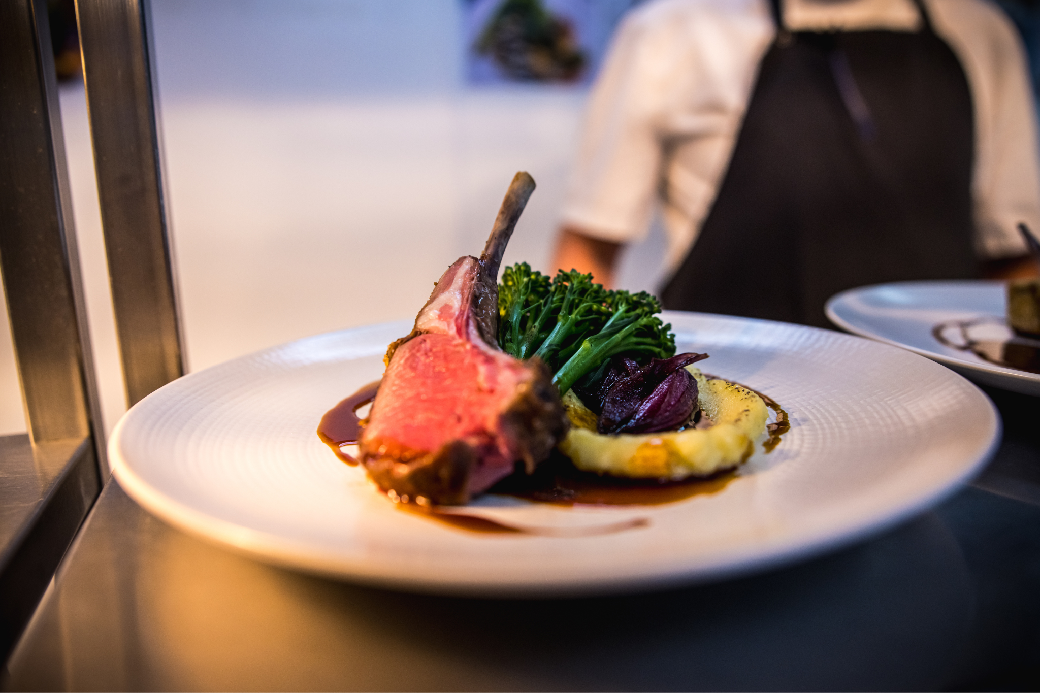 Elegant lamb chop dish with broccolini at The Queen Charlotte, perfect for events.