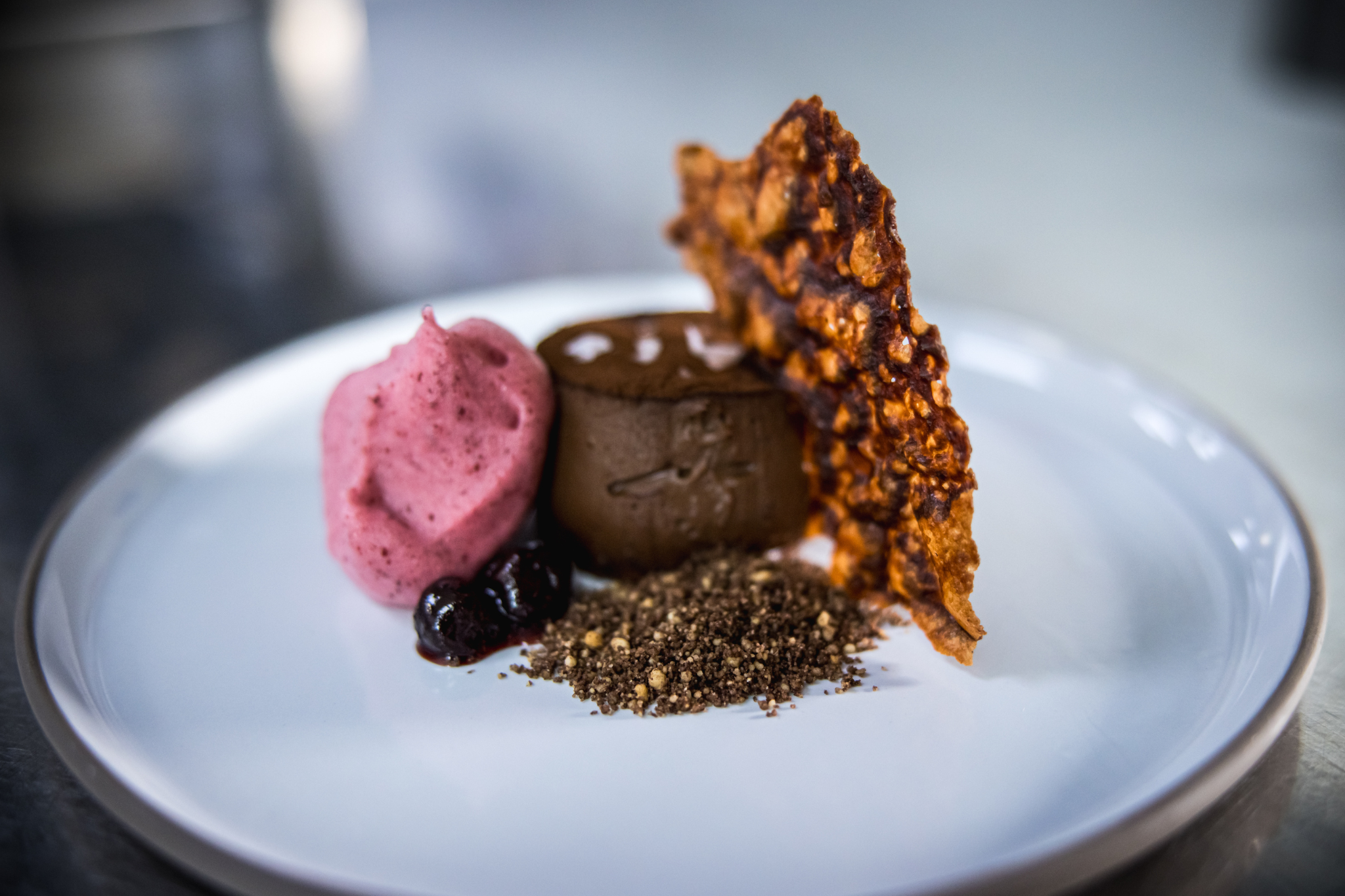 Elegant chocolate mousse dessert with berry sorbet for upscale events.
