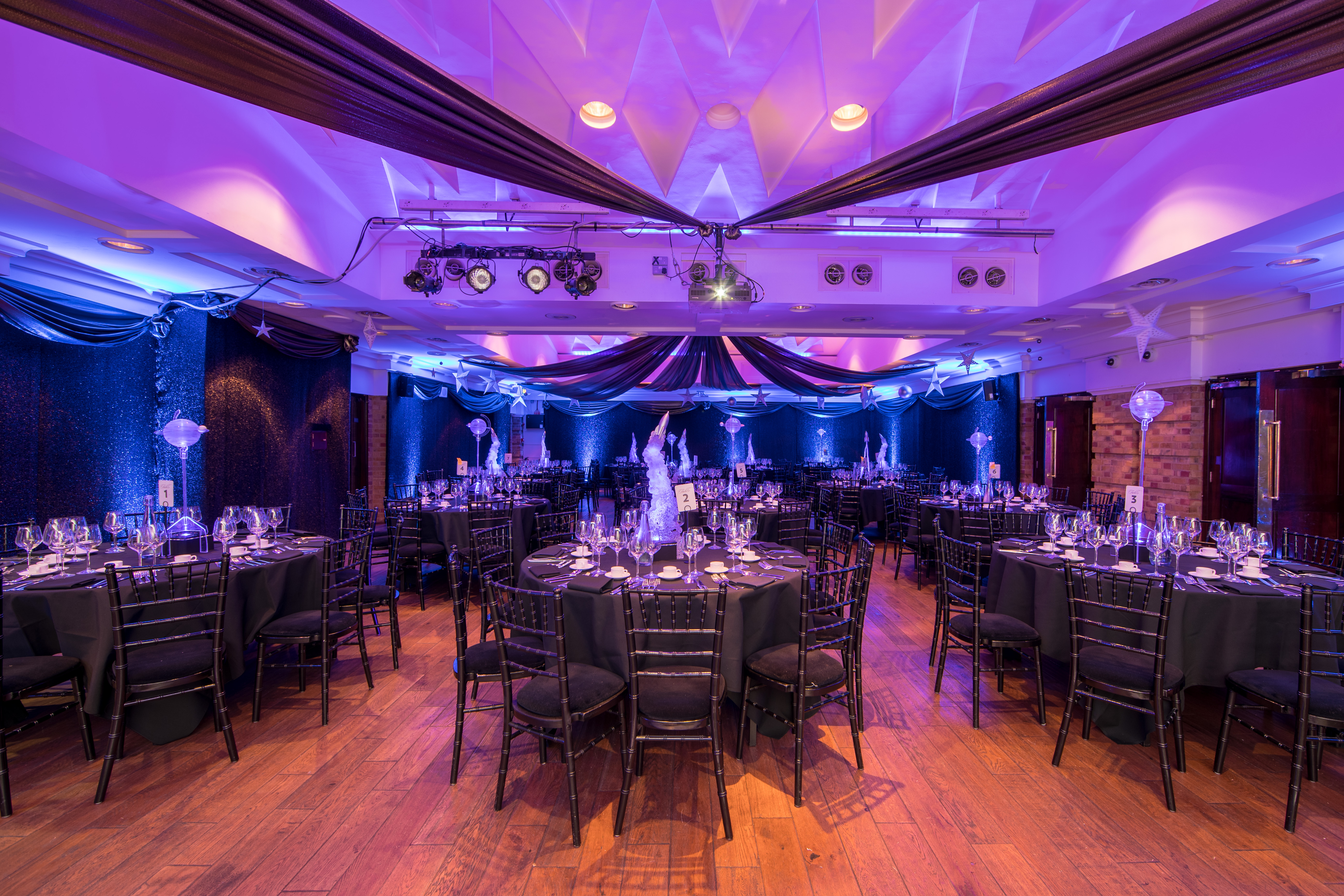 Elegant event space at The Queen Charlotte, featuring black and blue decor for corporate gatherings.