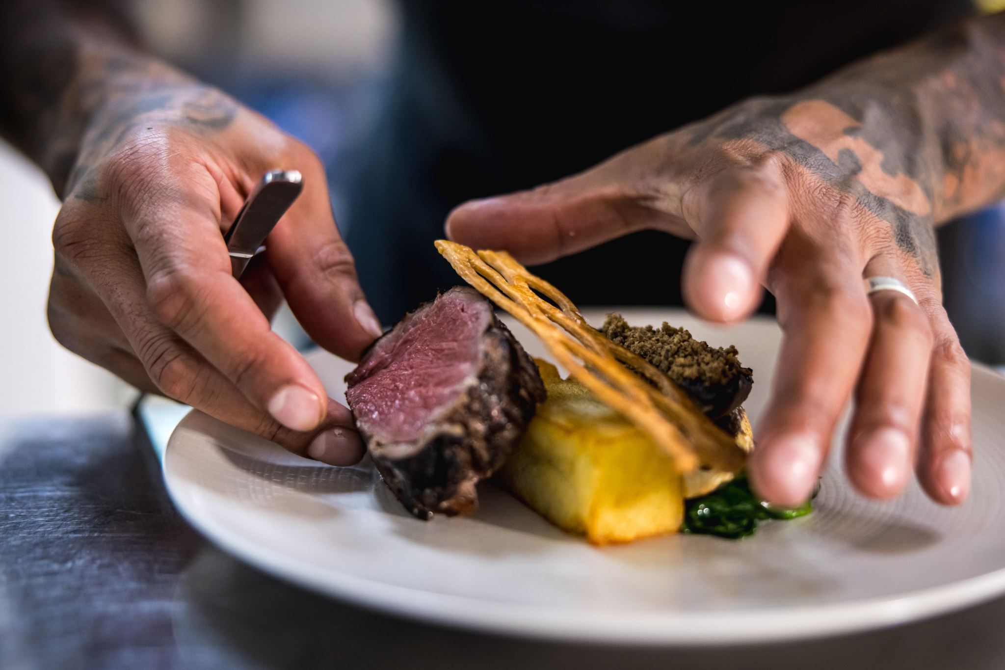 Chef plating gourmet dish at The James Watt, showcasing culinary artistry for upscale events.