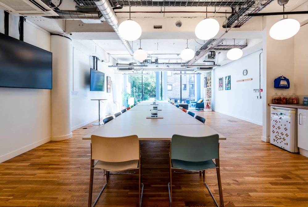 Modern meeting space with sleek table, ideal for workshops and corporate meetings.