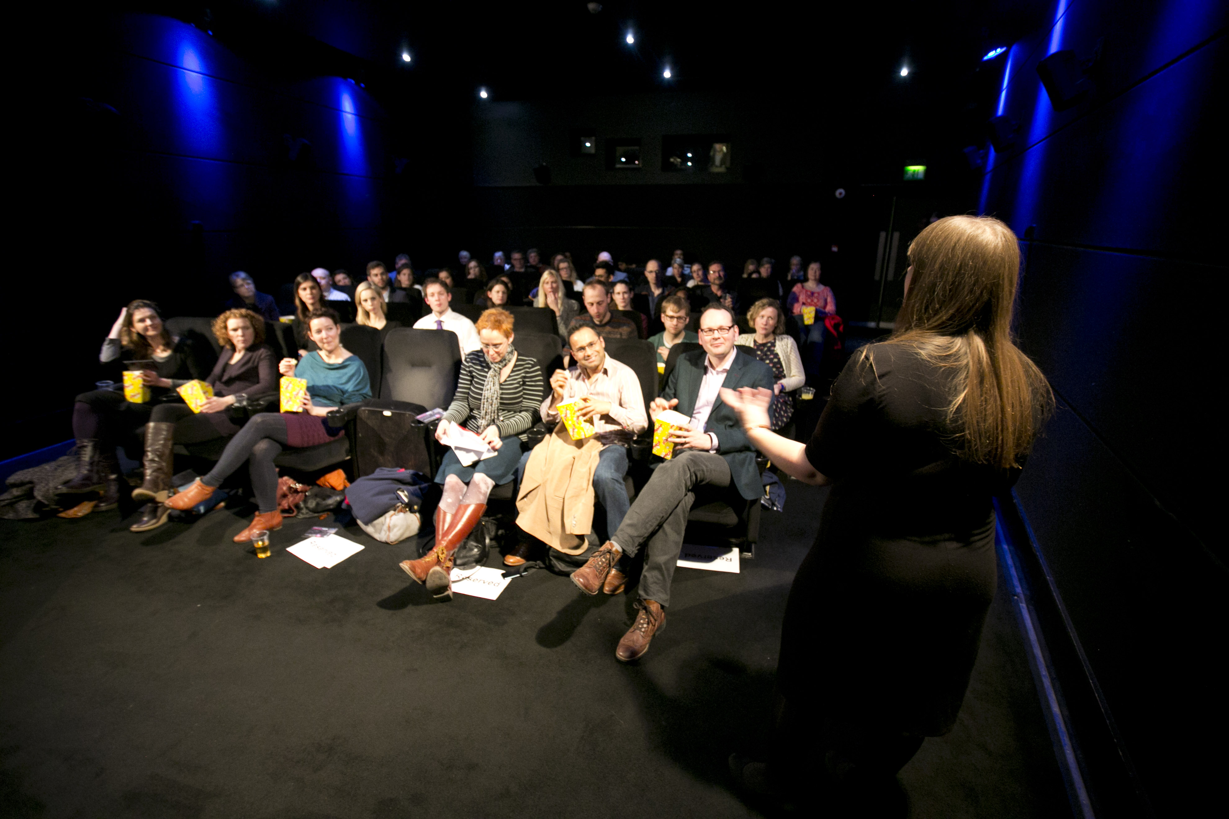 Engaged audience in dark theater setting at Rich Mix for a professional workshop event.
