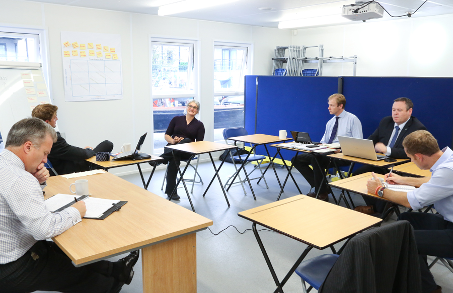 Seminar room with professionals discussing ideas, ideal for training and collaboration.