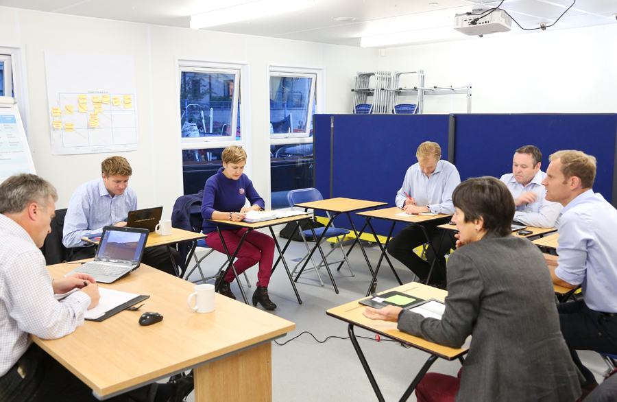 Seminar room with professionals collaborating, ideal for training and project management.
