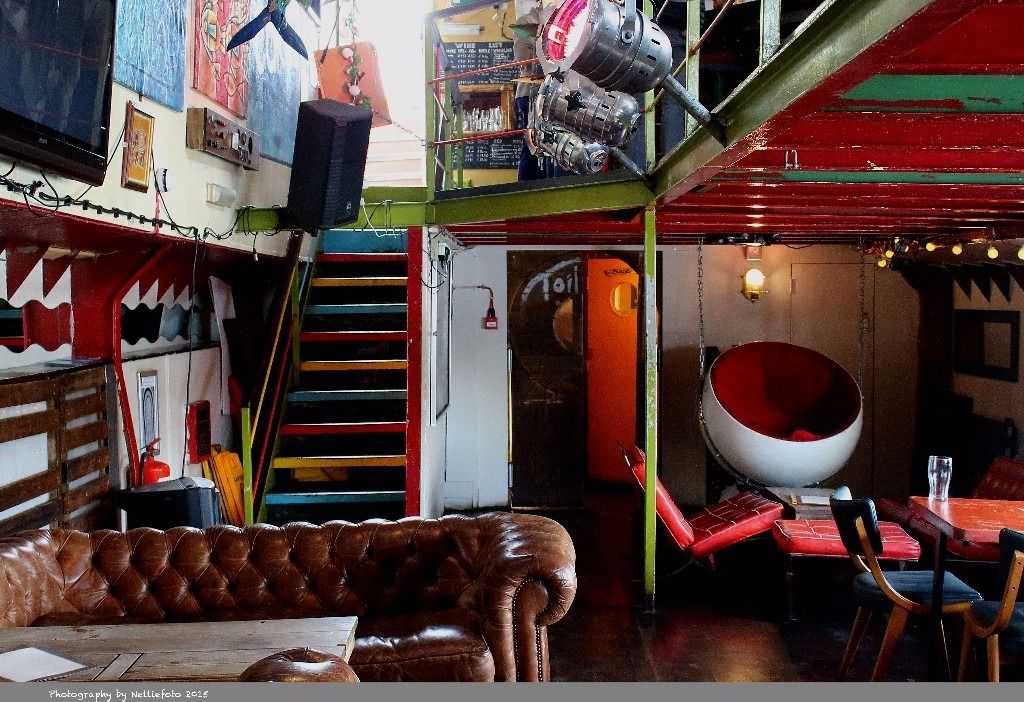 Vibrant event space at Tamesis Dock with colorful decor and unique hanging chair.