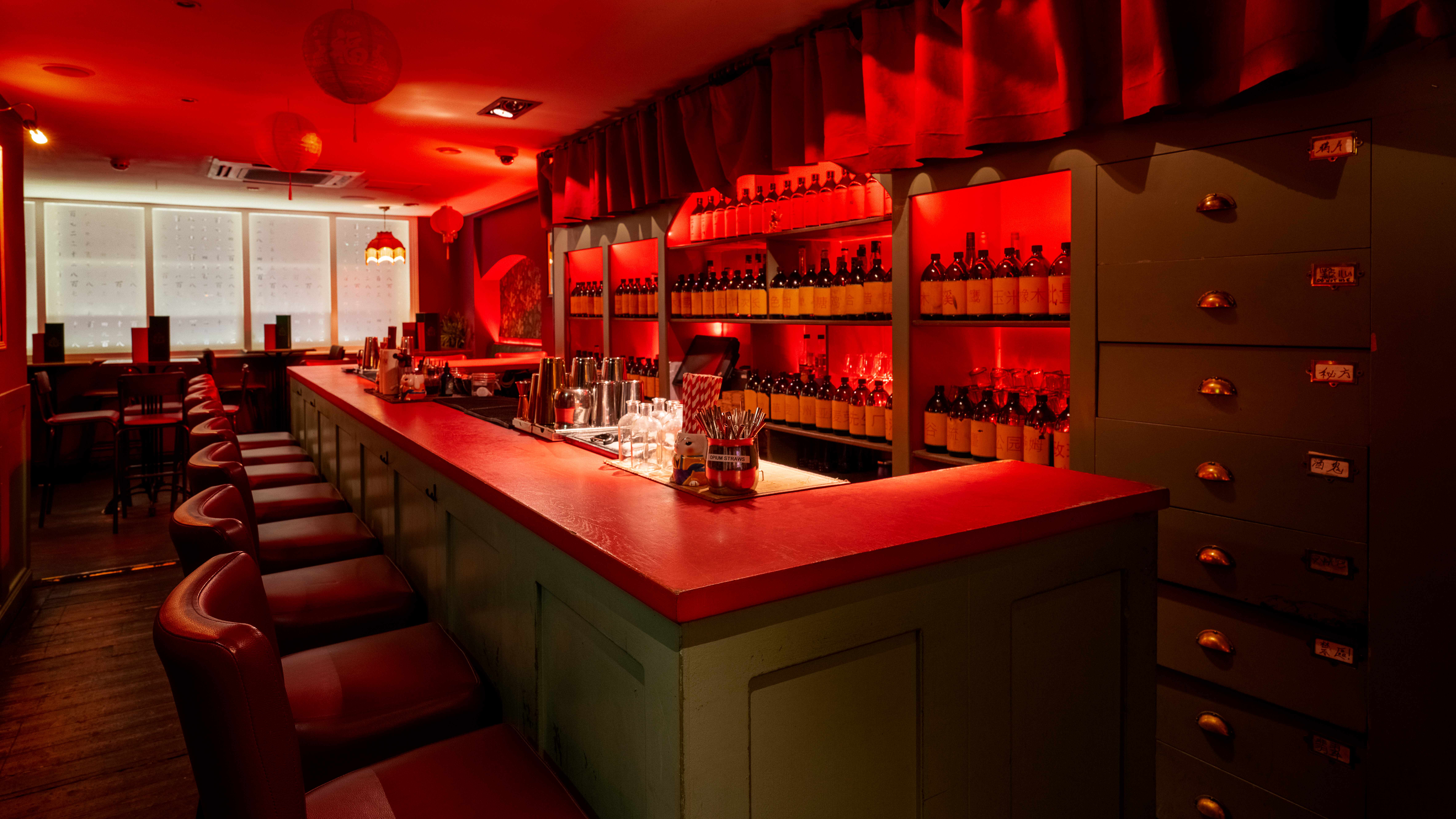Stylish Apothecary Bar with red lighting, perfect for cocktail receptions and networking events.