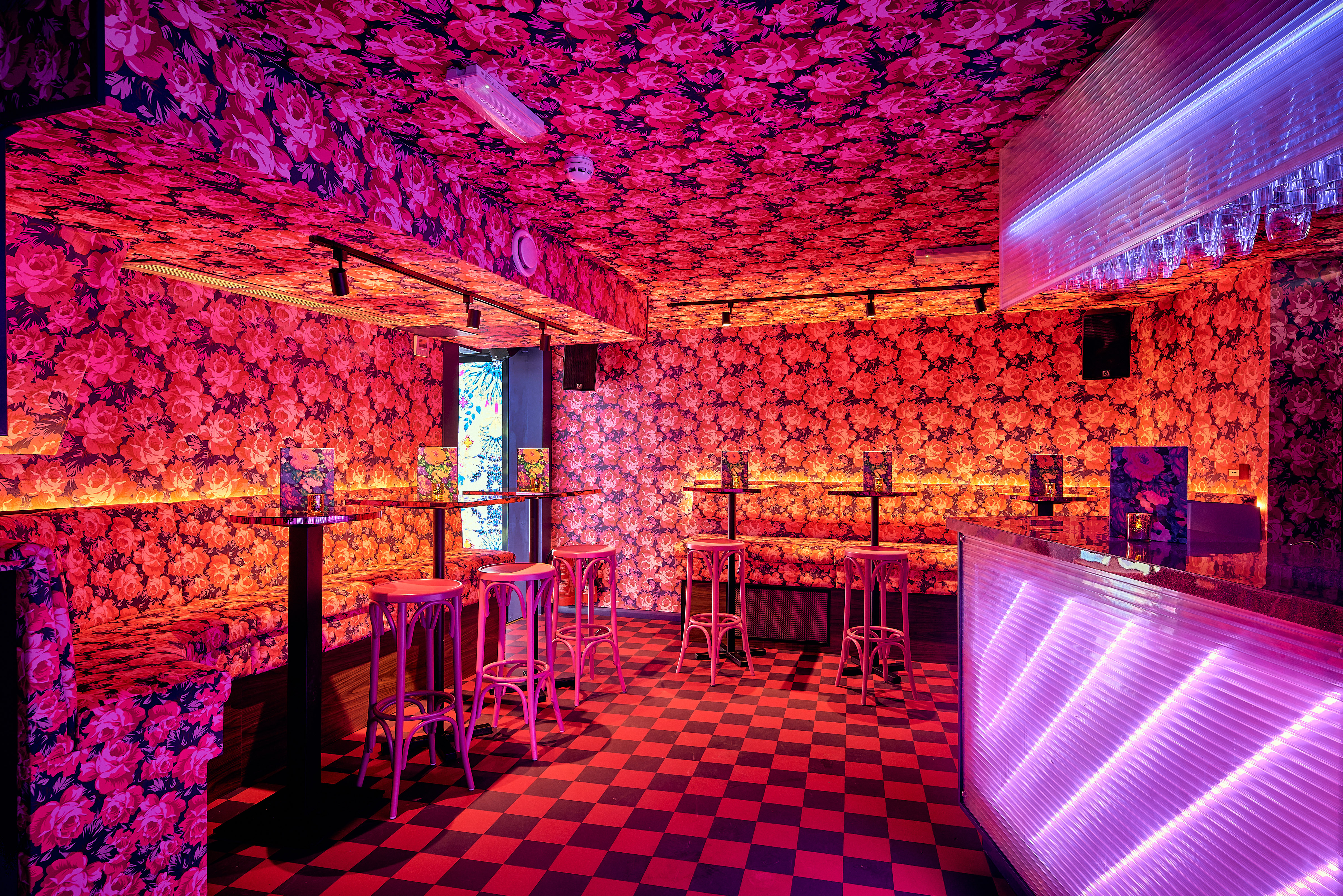 Vibrant Blame Gloria venue with floral wallpaper, ideal for events and gatherings.