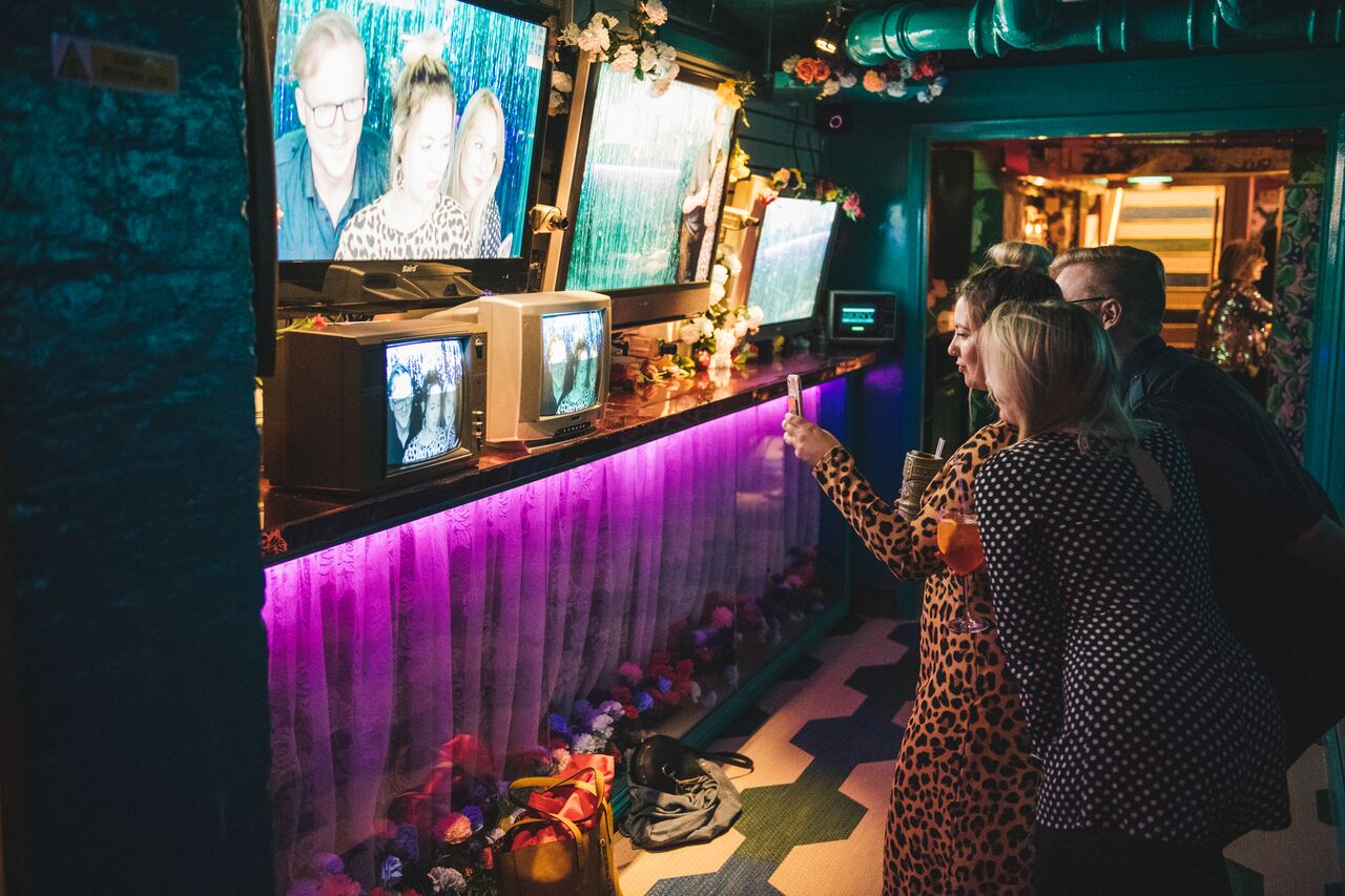 Vibrant event space at Blame Gloria with retro TVs for themed gatherings and networking.