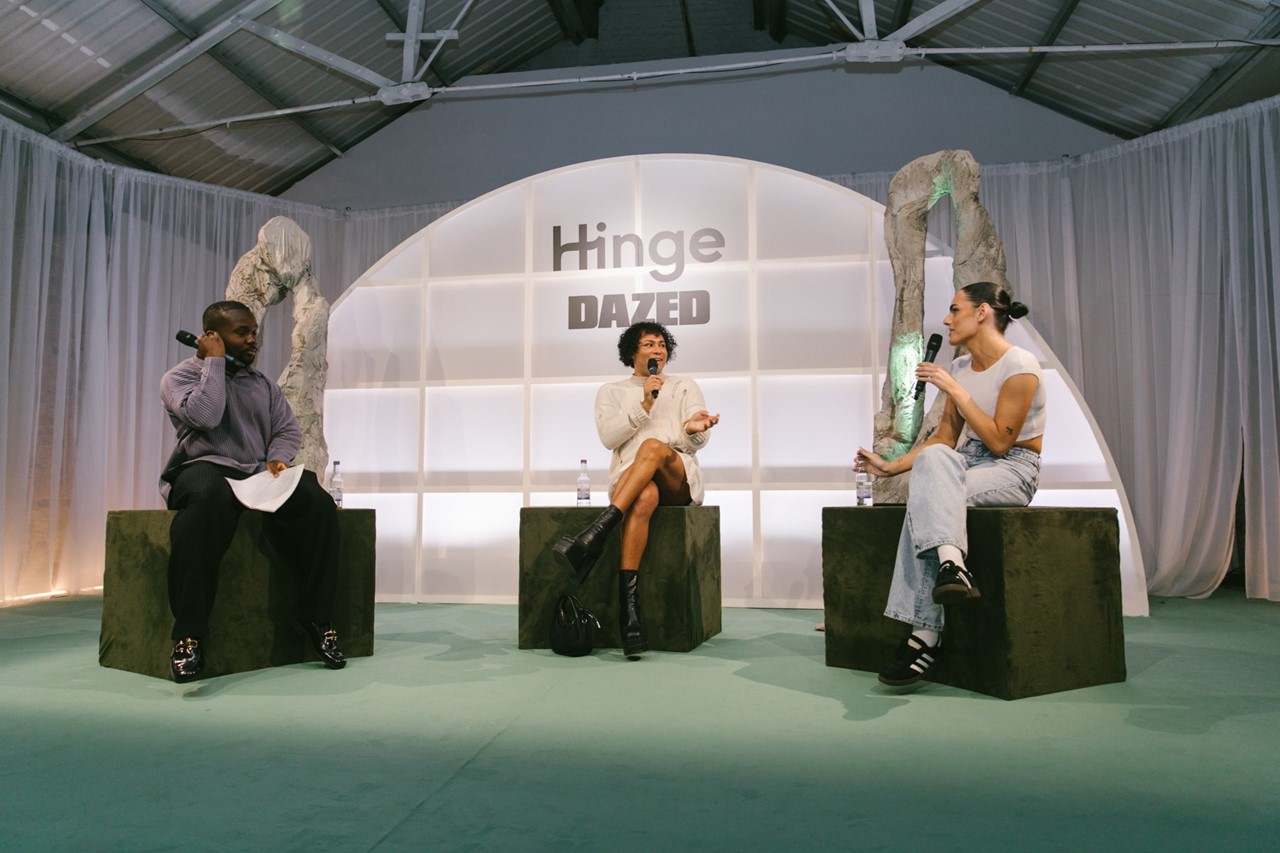 Panel discussion setup at Shoreditch Studios with three speakers and modern stage design.