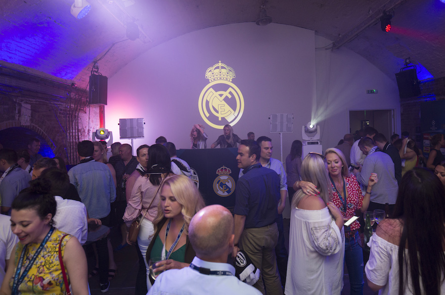 Vibrant corporate event in Shoreditch Studios with Real Madrid branding and DJ setup.