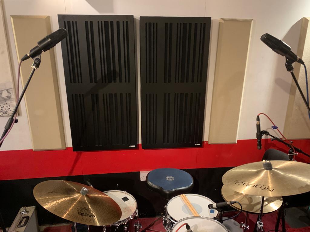 Music studio with drum kit and microphones, perfect for workshops and live performances.
