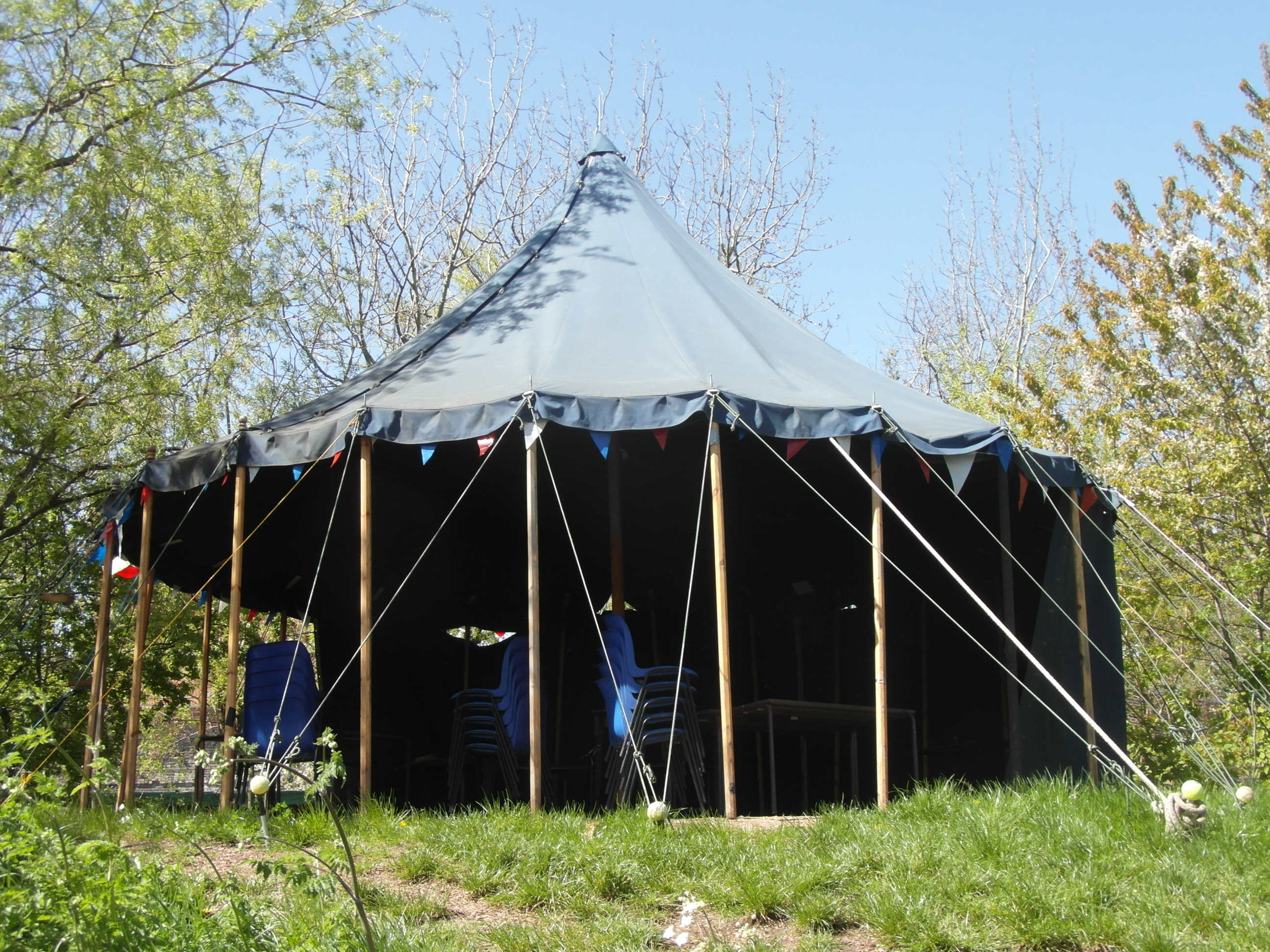 Outdoor kitchen tent with bunting for weddings and corporate retreats in London park.
