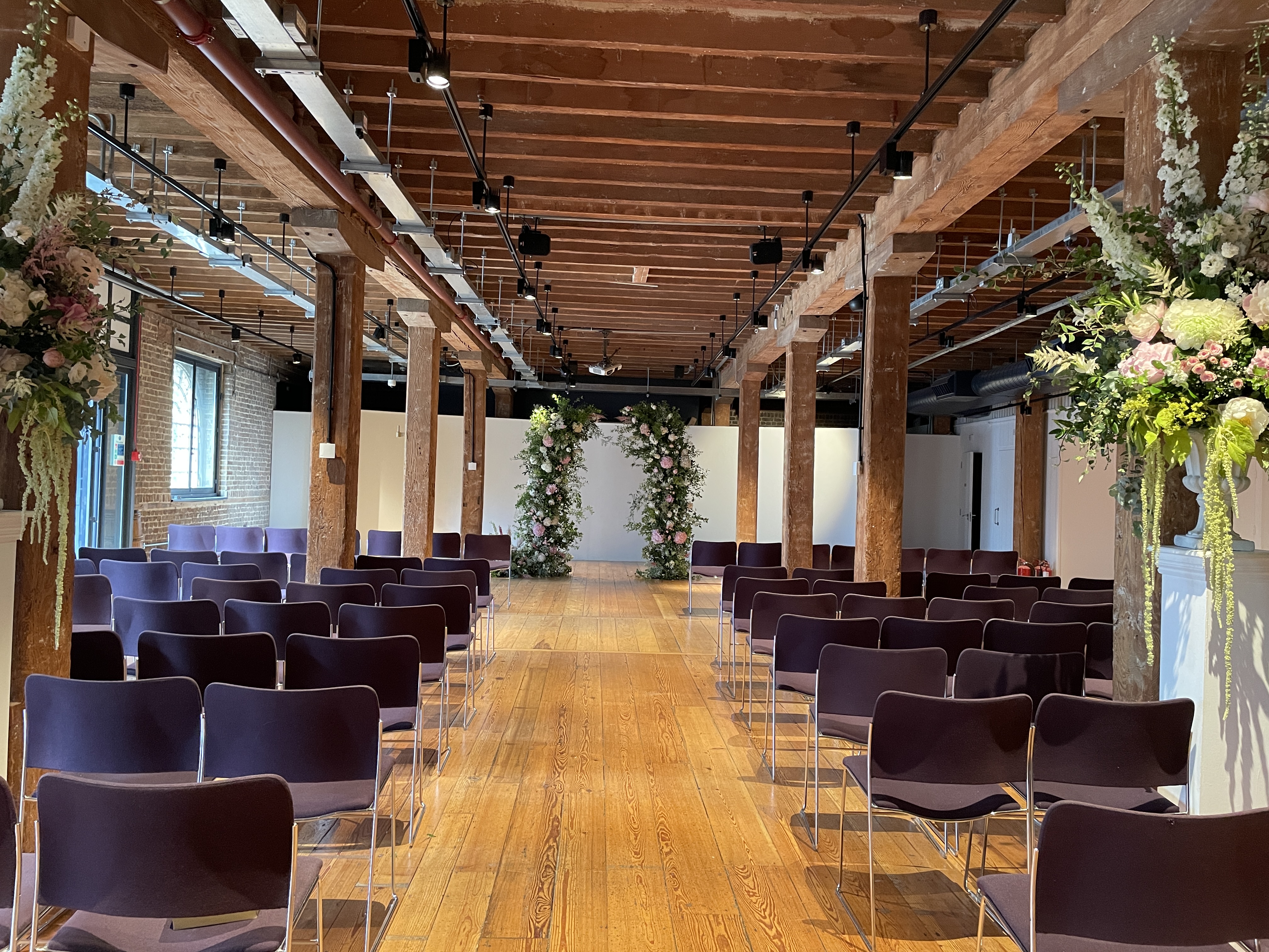 Elegant wedding venue with floral arrangements at Rum Store, London Museum Docklands.