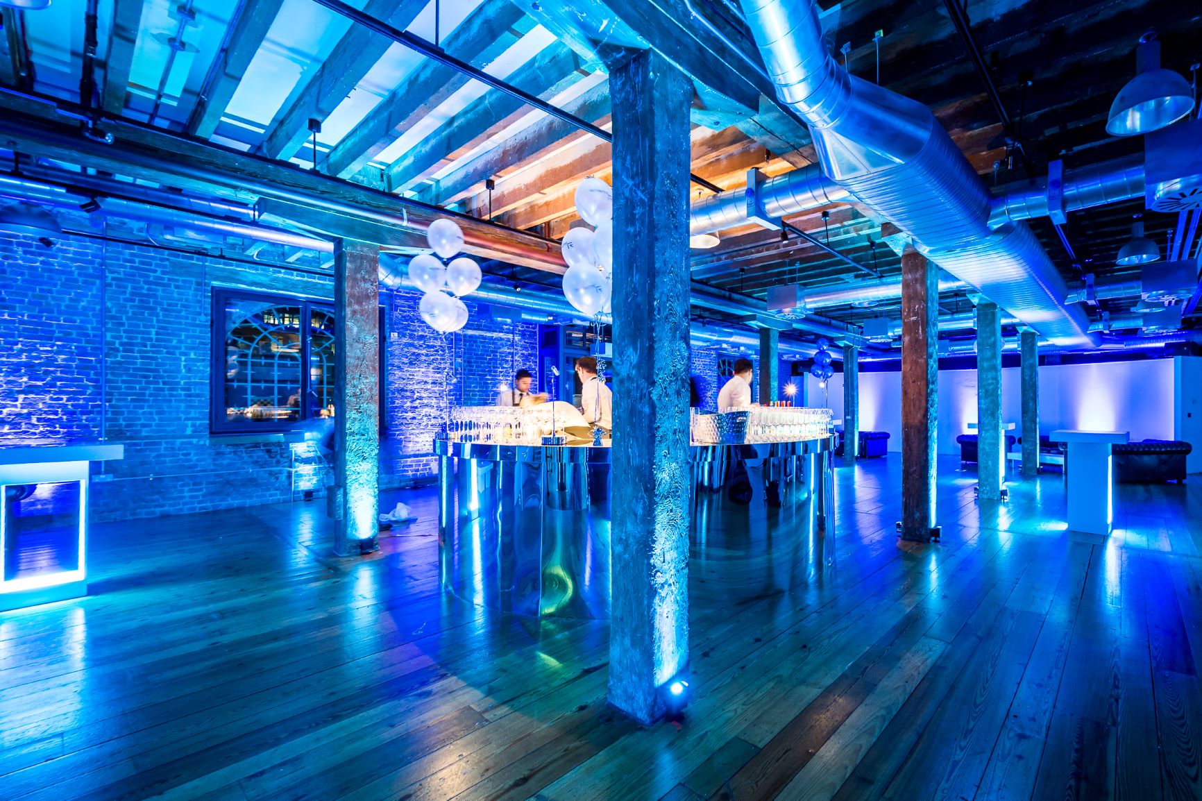 Modern event space at Rum Store, London Docklands, with vibrant blue lighting for gatherings.