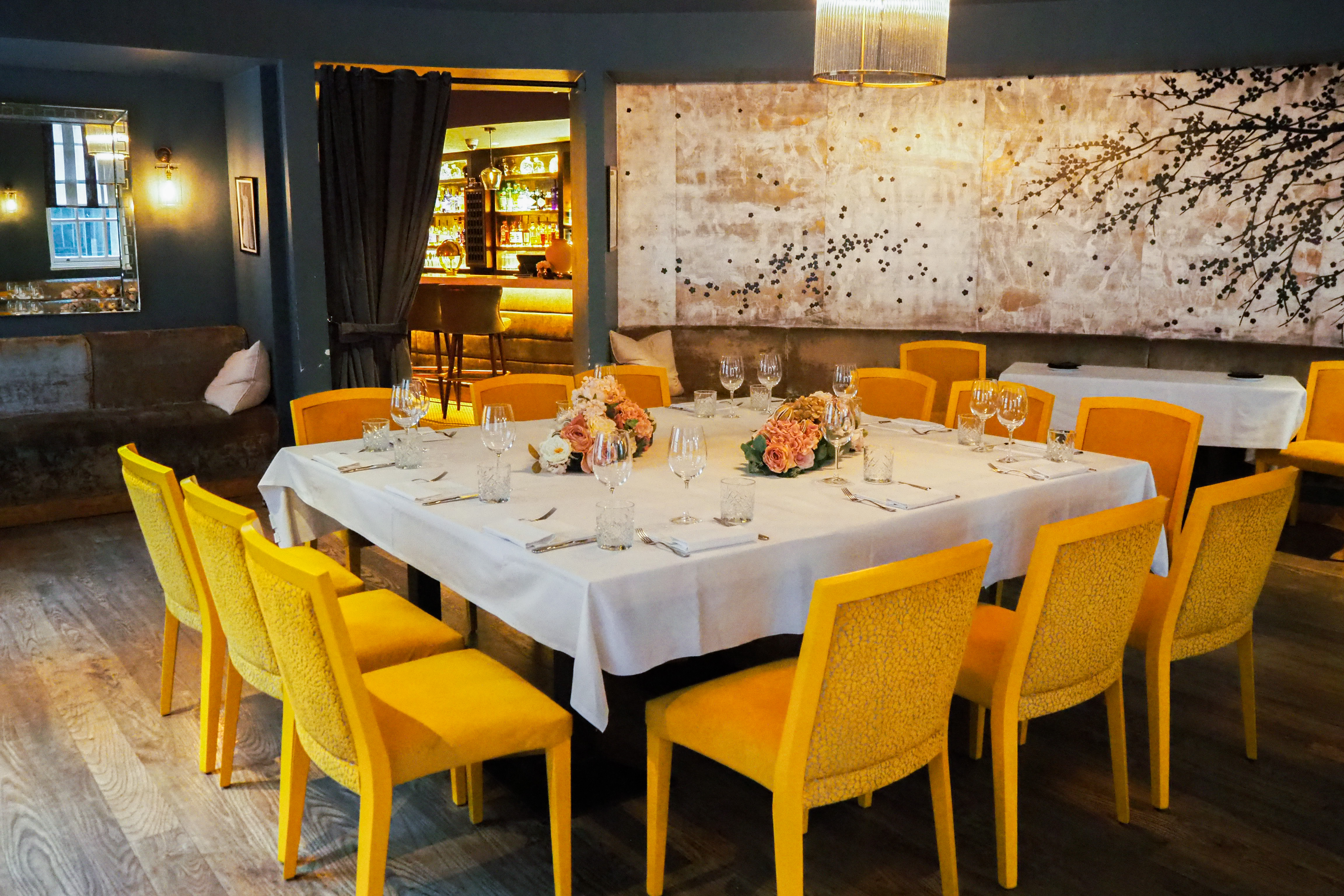 Stylish dining space in Hush Mayfair with vibrant yellow chairs for corporate events.