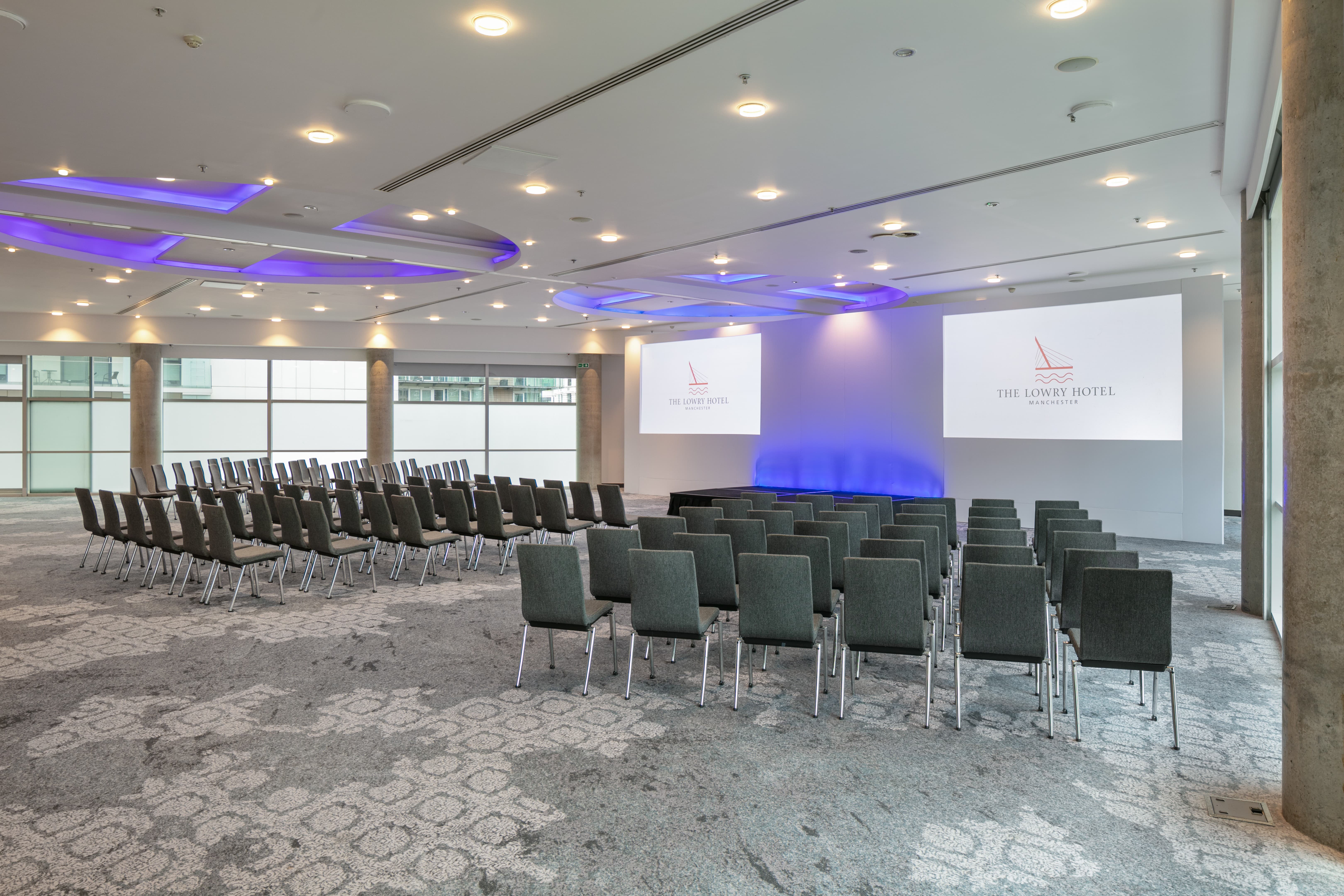 Grand Ballroom theater-style setup with purple lighting for corporate conferences and keynotes.