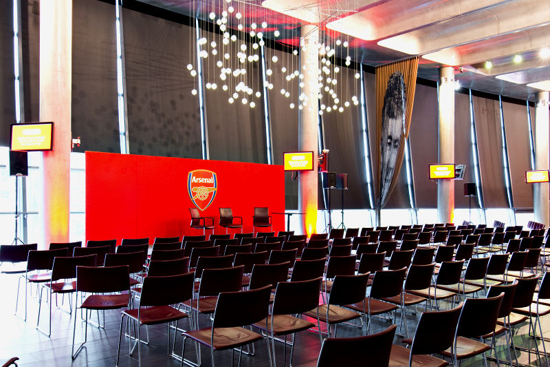 Event space at Emirates Stadium with red Arsenal backdrop for corporate events.
