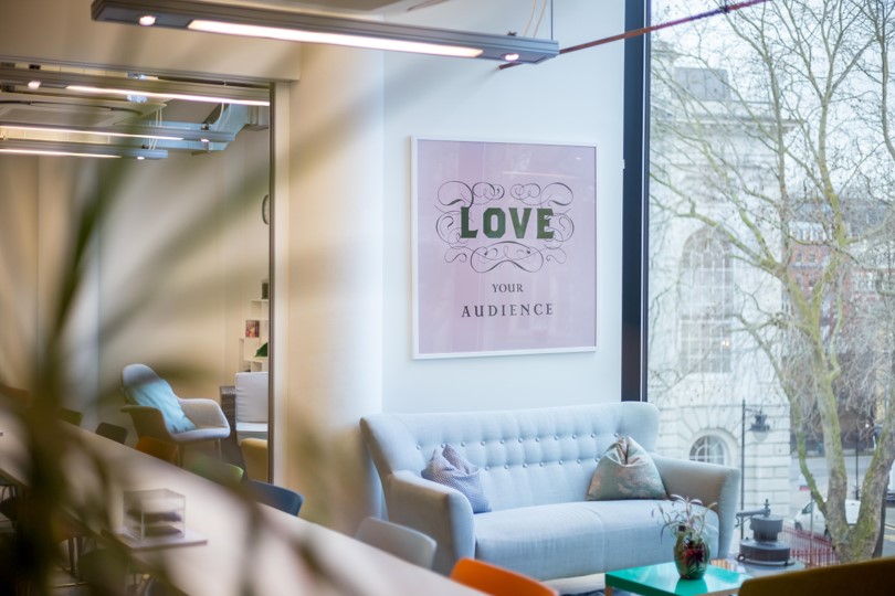 Modern meeting space with inviting sofa and vibrant artwork for creative collaboration.