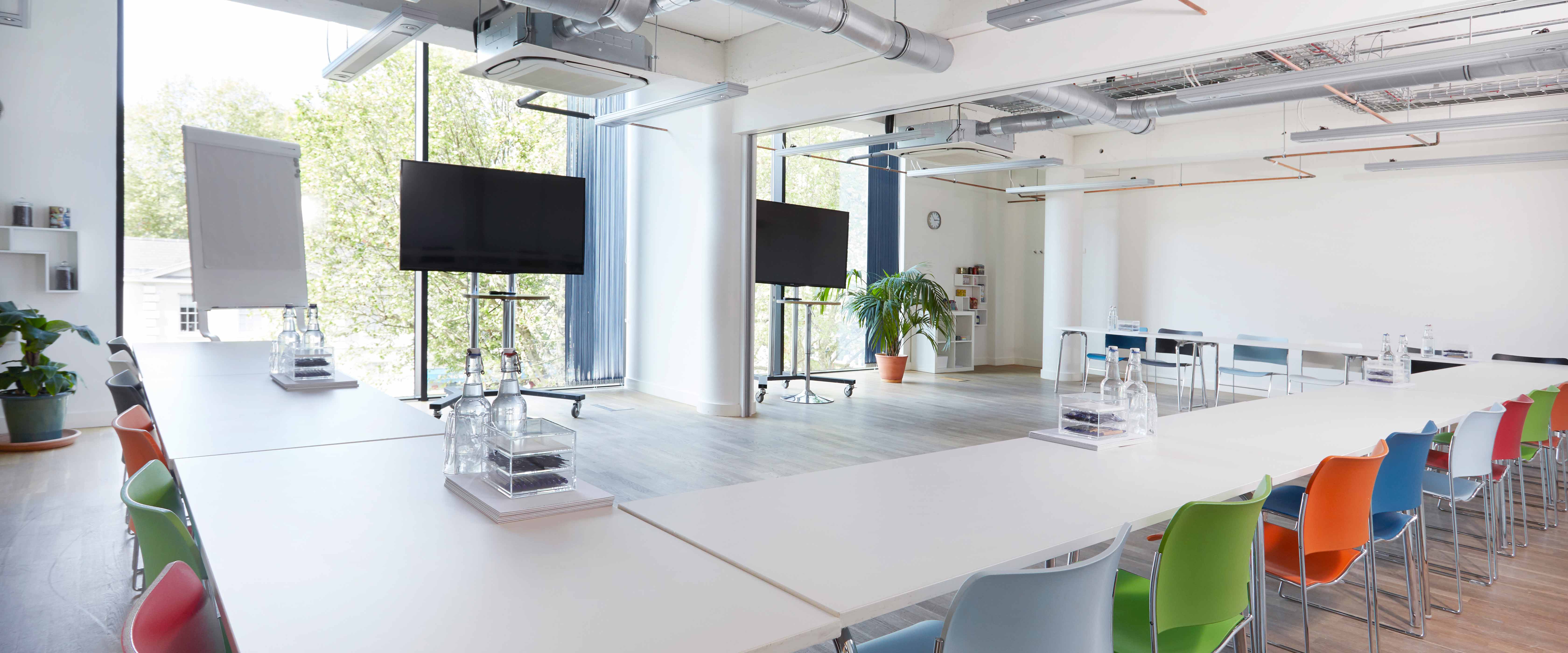 Modern meeting space with large screens, ideal for workshops and corporate events.