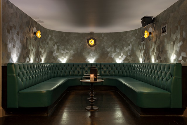 Stylish seating area with plush green banquette for networking events at Dirty Martini.