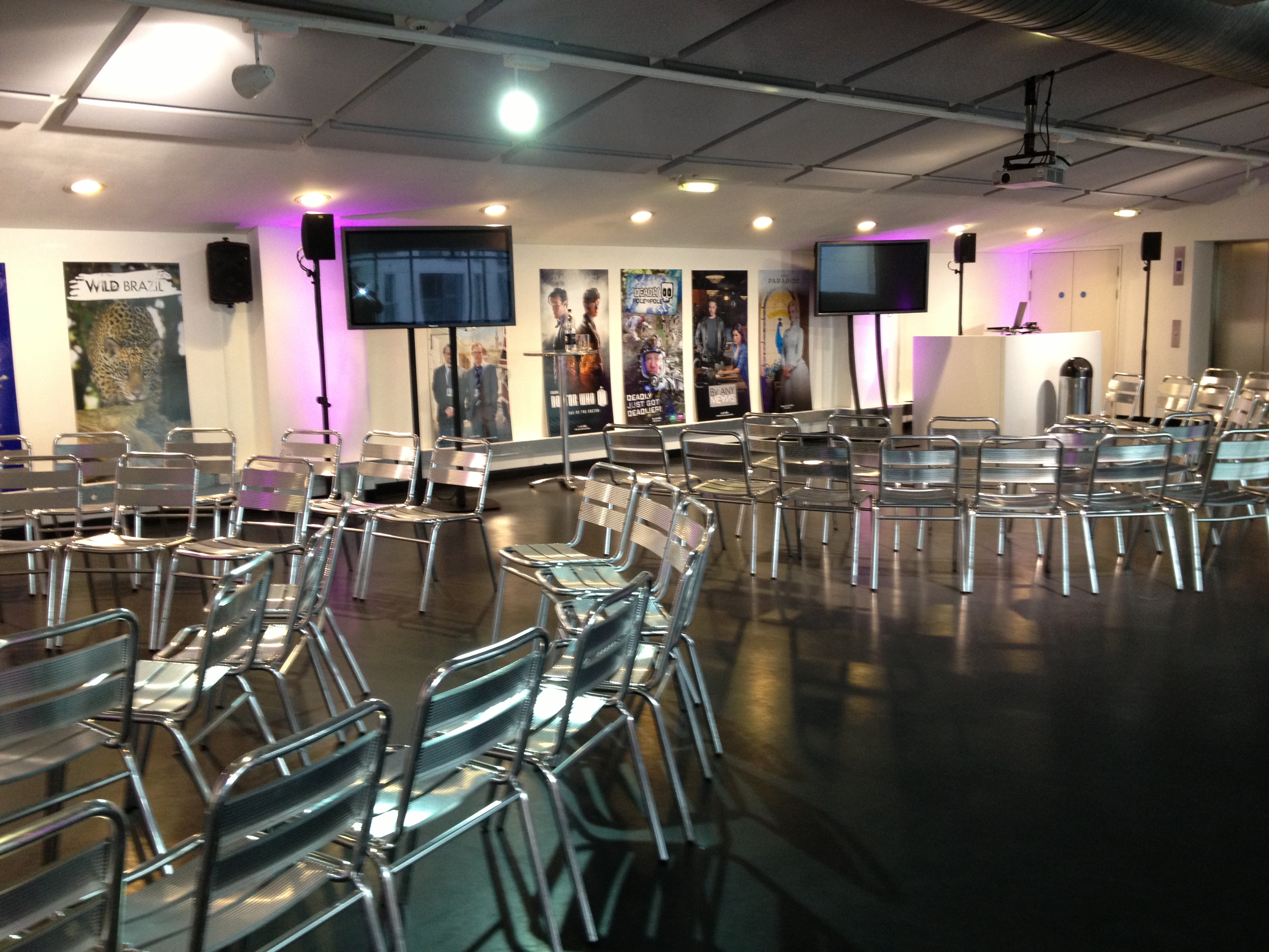 Versatile meeting space at The Mix, featuring modern transparent chairs and dual screens.