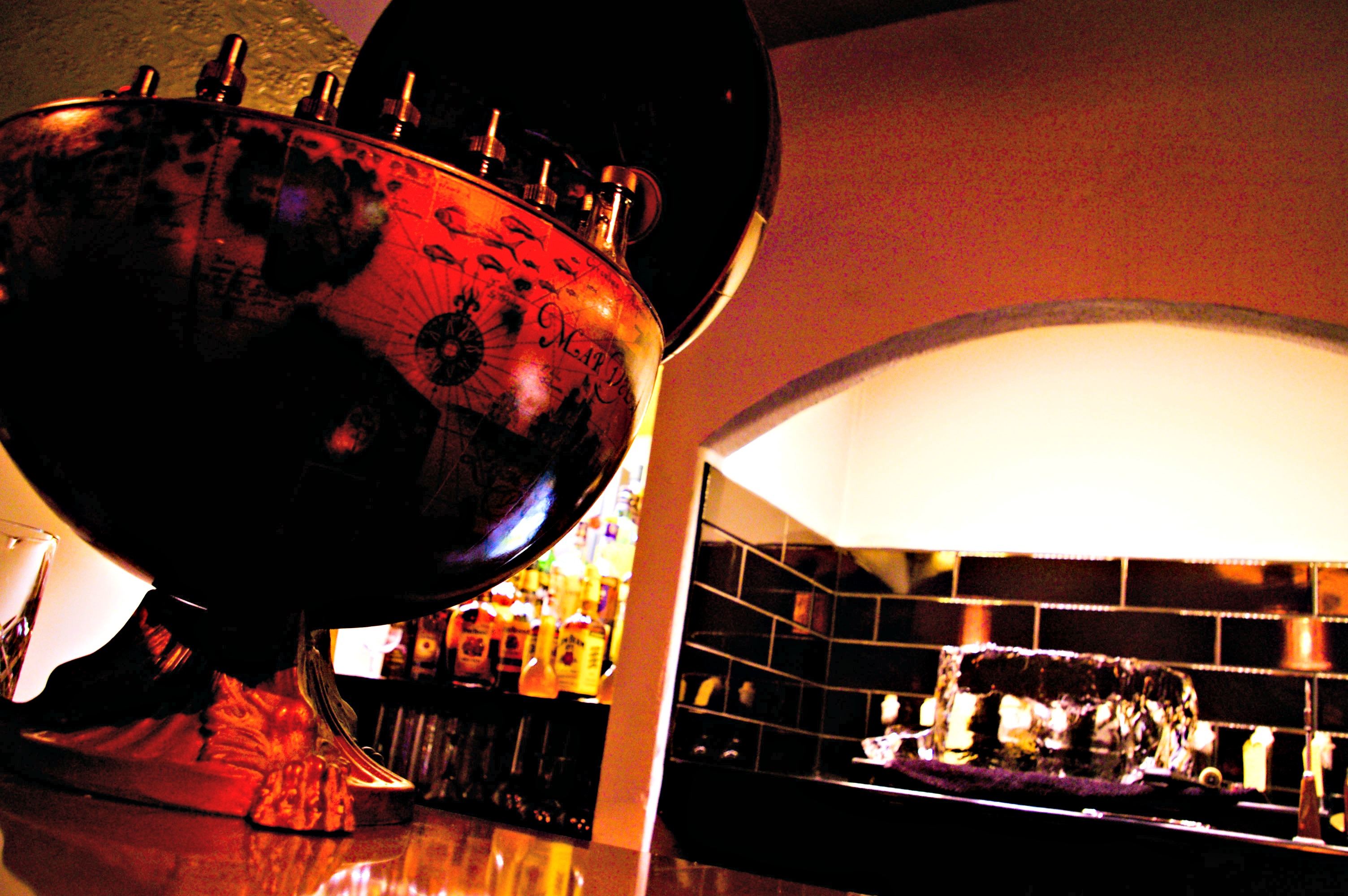 Stylish bar with globe drink dispenser at upscale Purl London venue for events.
