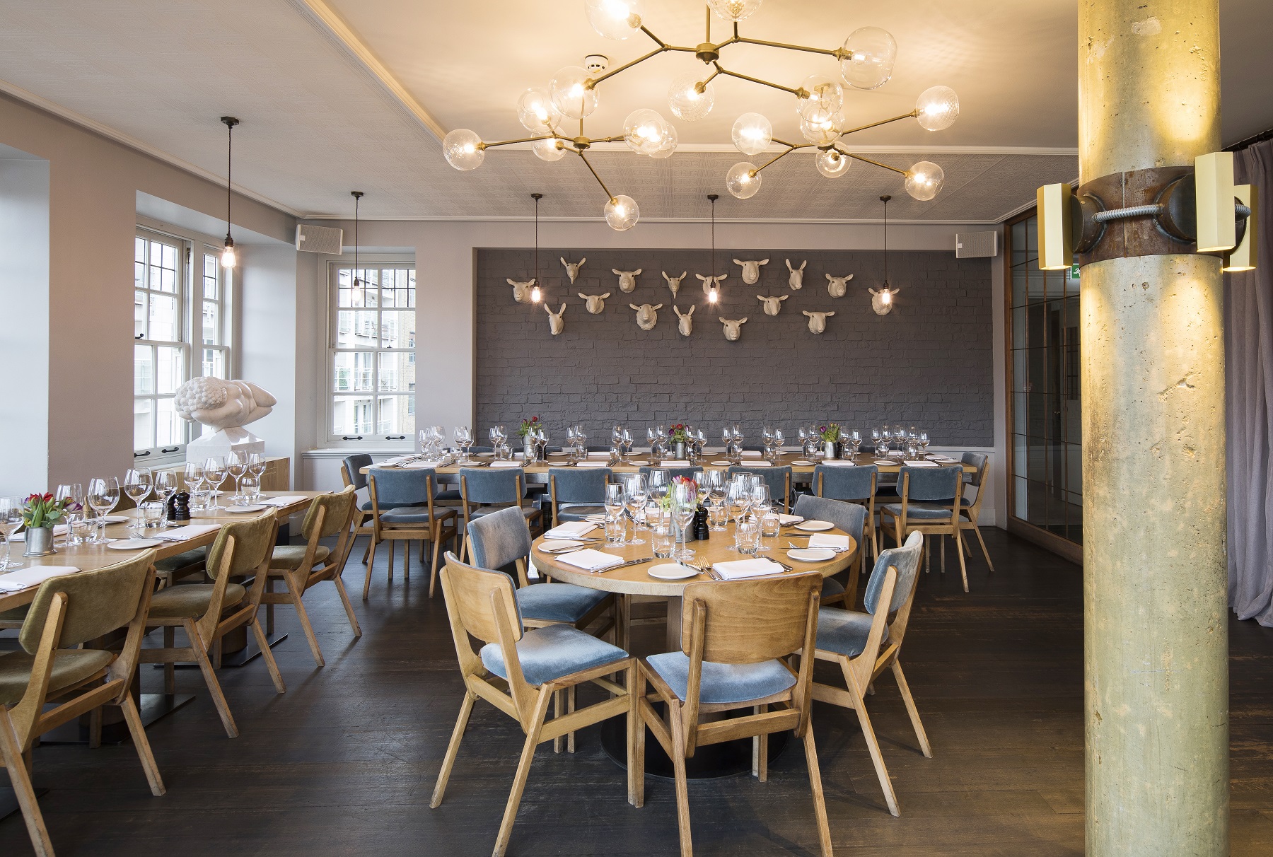 Stylish event space with round tables and modern decor for corporate dinners or gatherings.