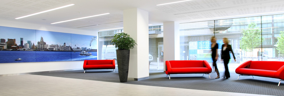 Modern lobby with vibrant red sofas, ideal for meetings and events at The Plaza.
