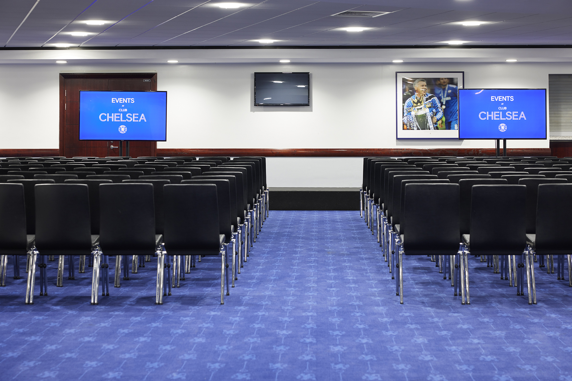 Drake and Harris Suites at Chelsea FC, elegant conference setup with multimedia display.