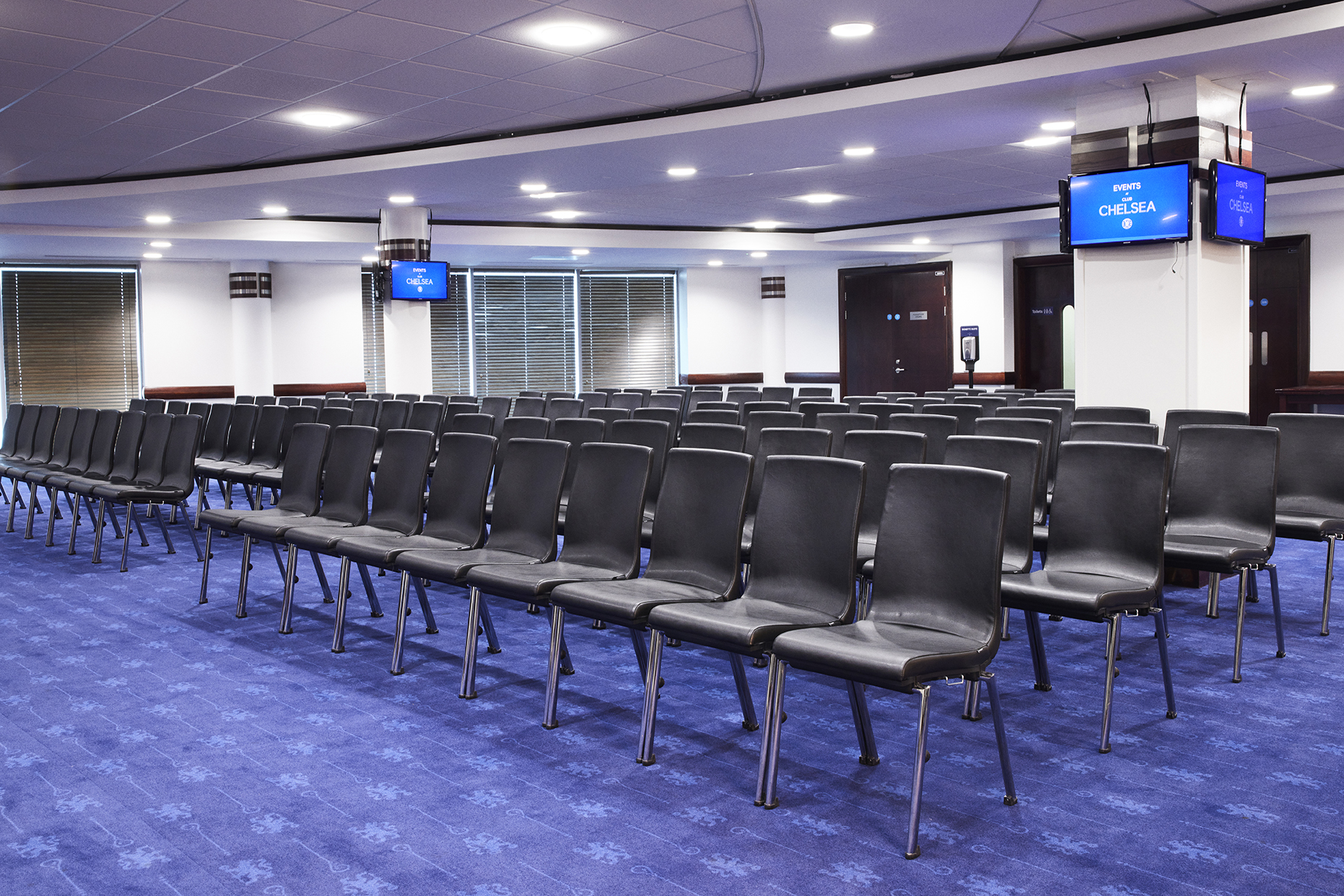 Bonnetti and Clarke Suites at Chelsea FC, modern event space with black chairs for seminars.