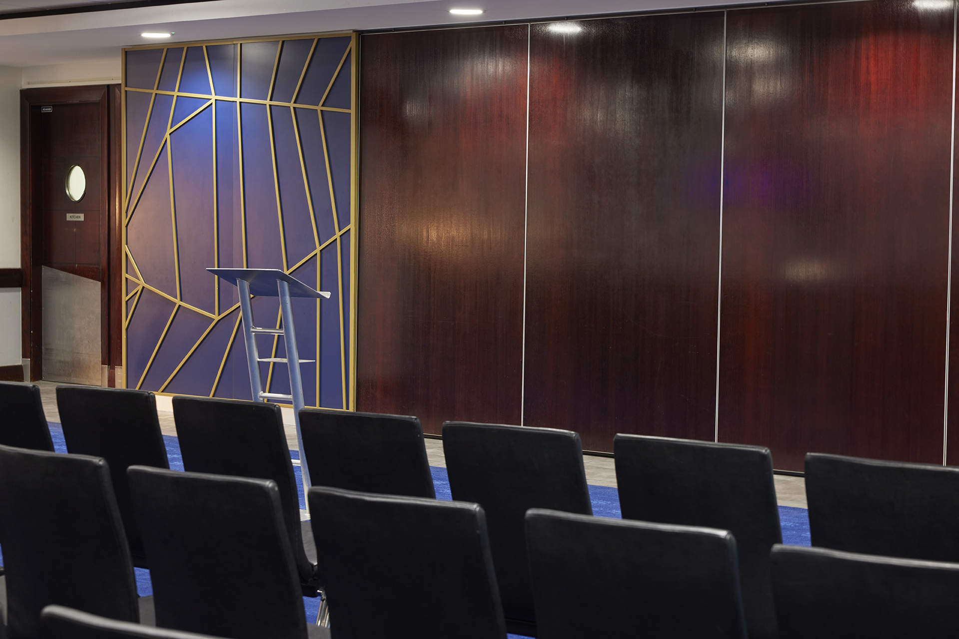 Tambling Suite at Chelsea FC: modern event space with podium, ideal for meetings and conferences.