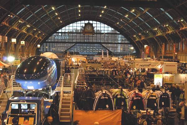 Charter Suite exhibition hall in Manchester Central, bustling with diverse booths and displays.