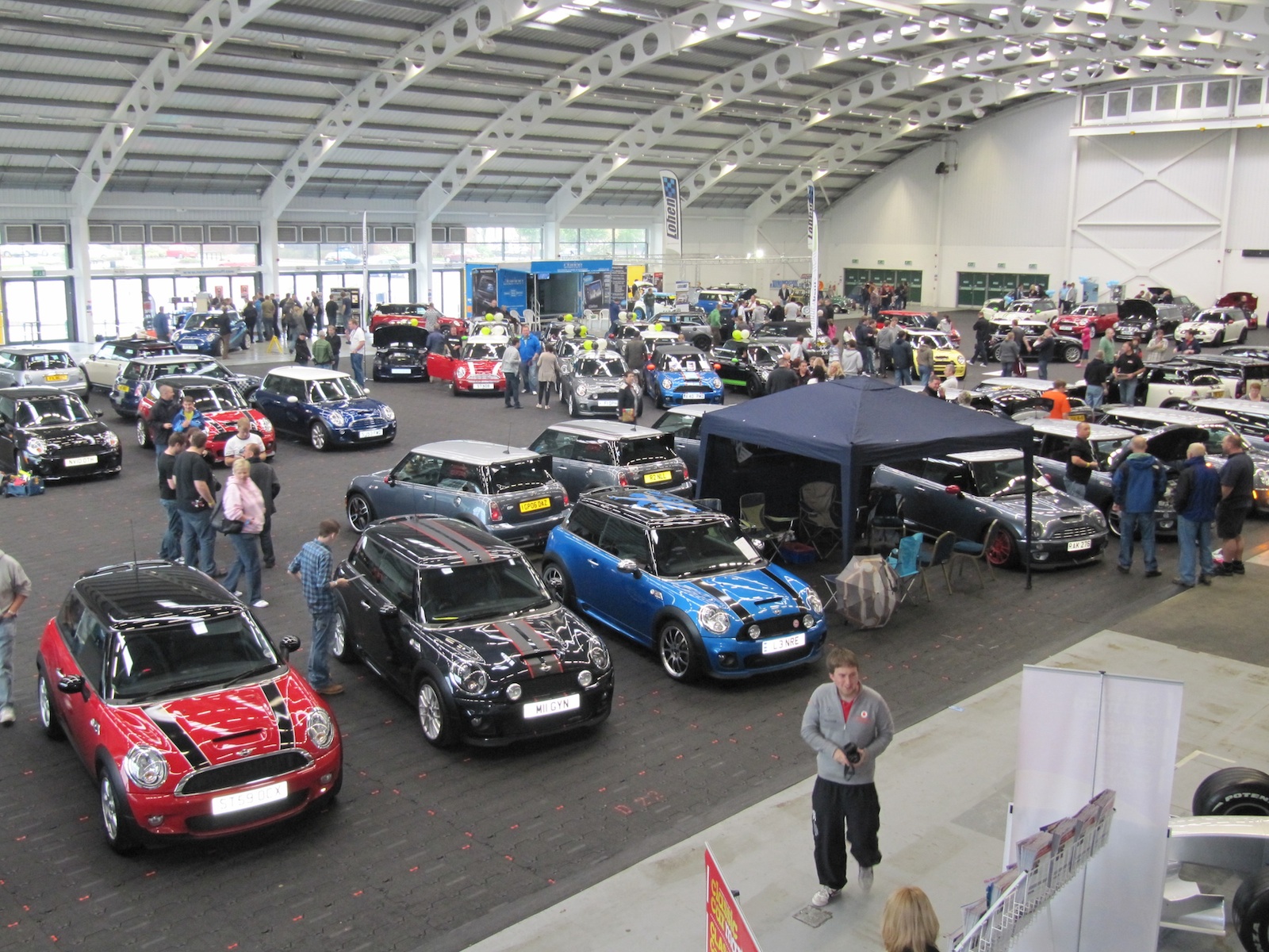 Aintree Racecourse exhibition with car models at an automotive trade show.