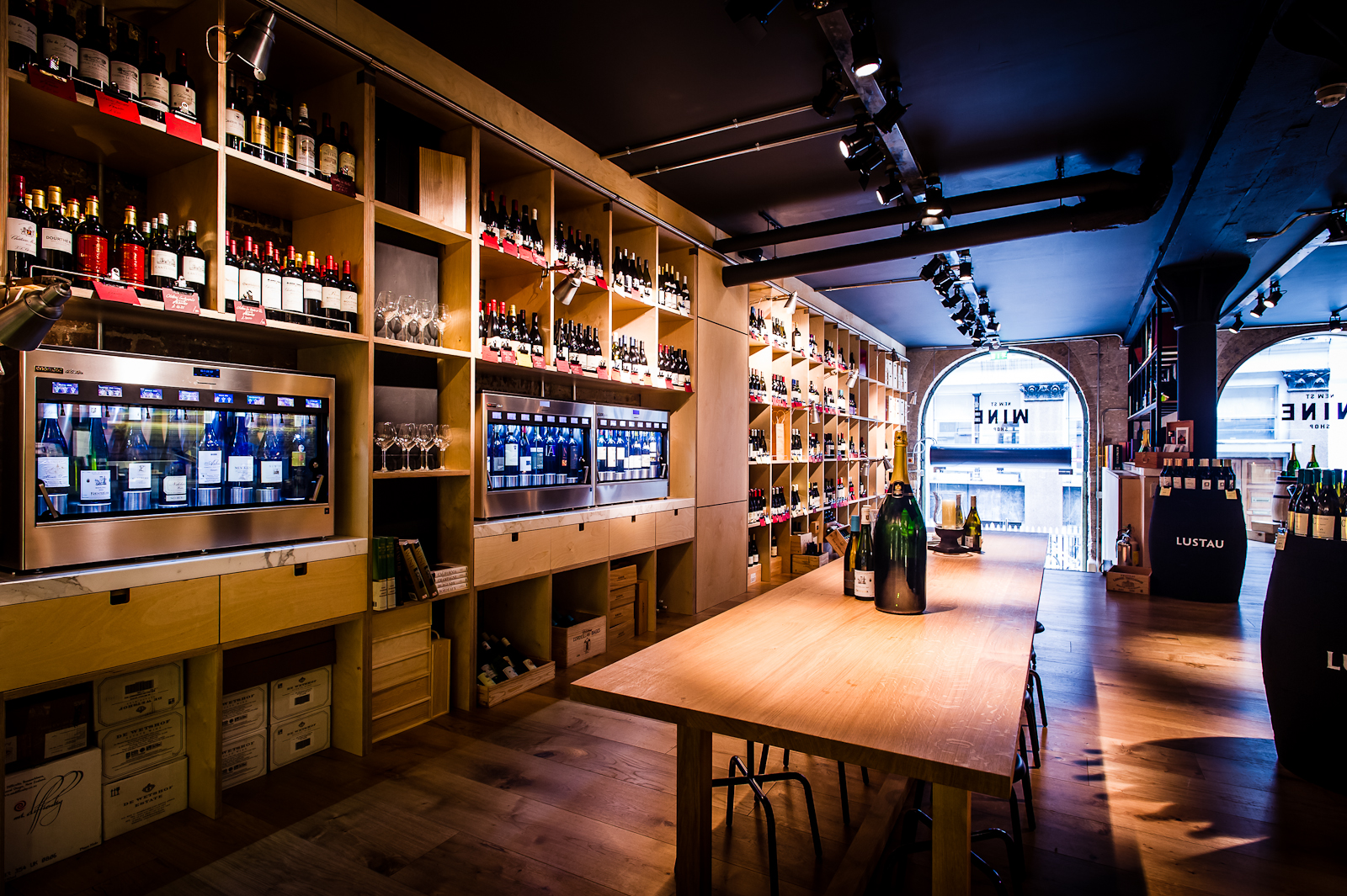 Stylish wine shop venue with wooden shelves, ideal for corporate events and private tastings.