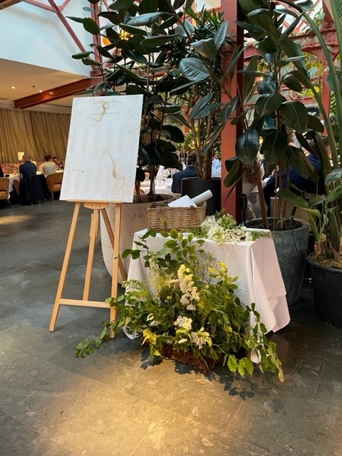 Elegant event space at Bluebird Chelsea with easel and floral arrangements.