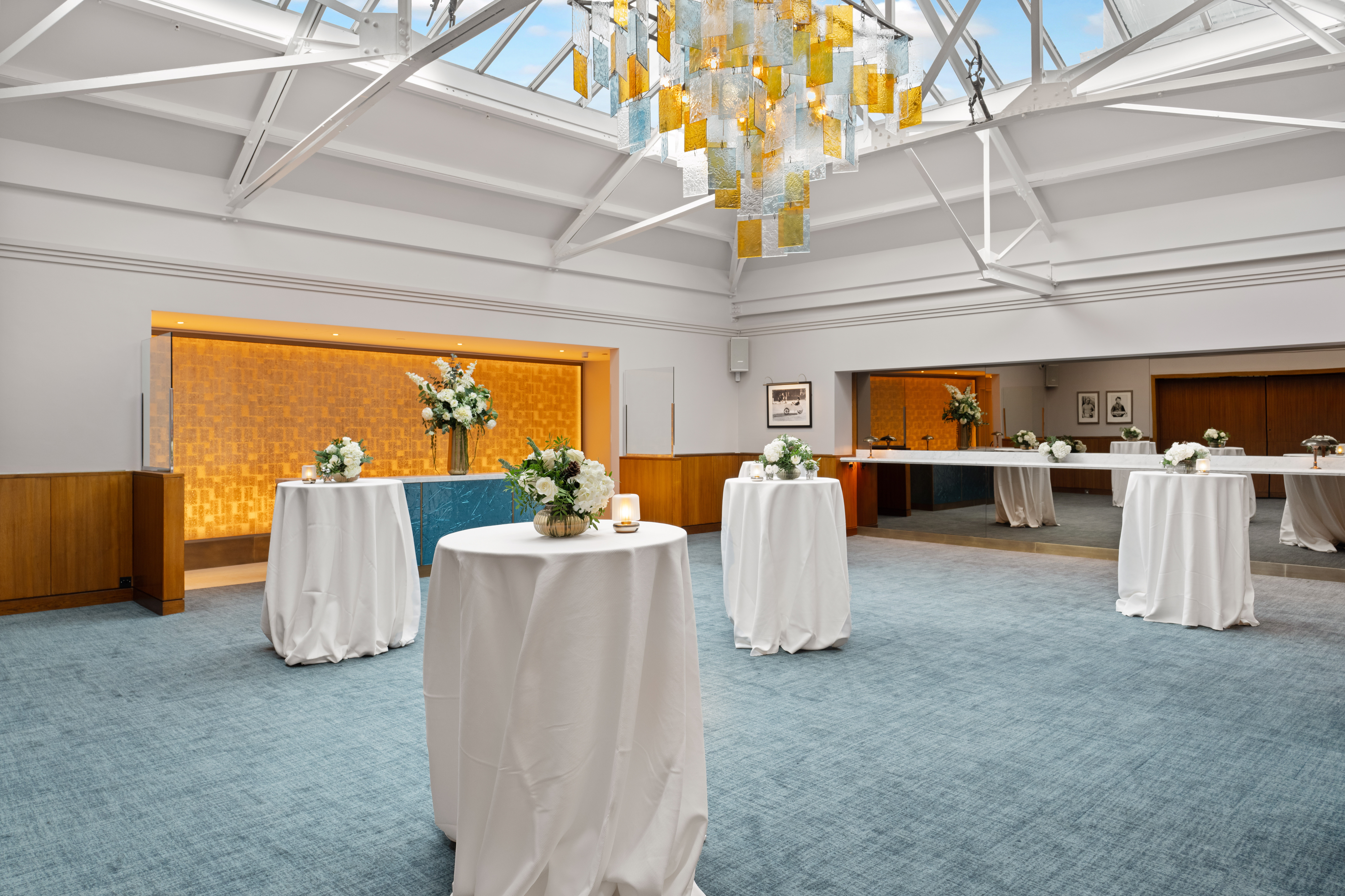 Elegant event space in Bluebird Chelsea with round tables and modern chandelier.
