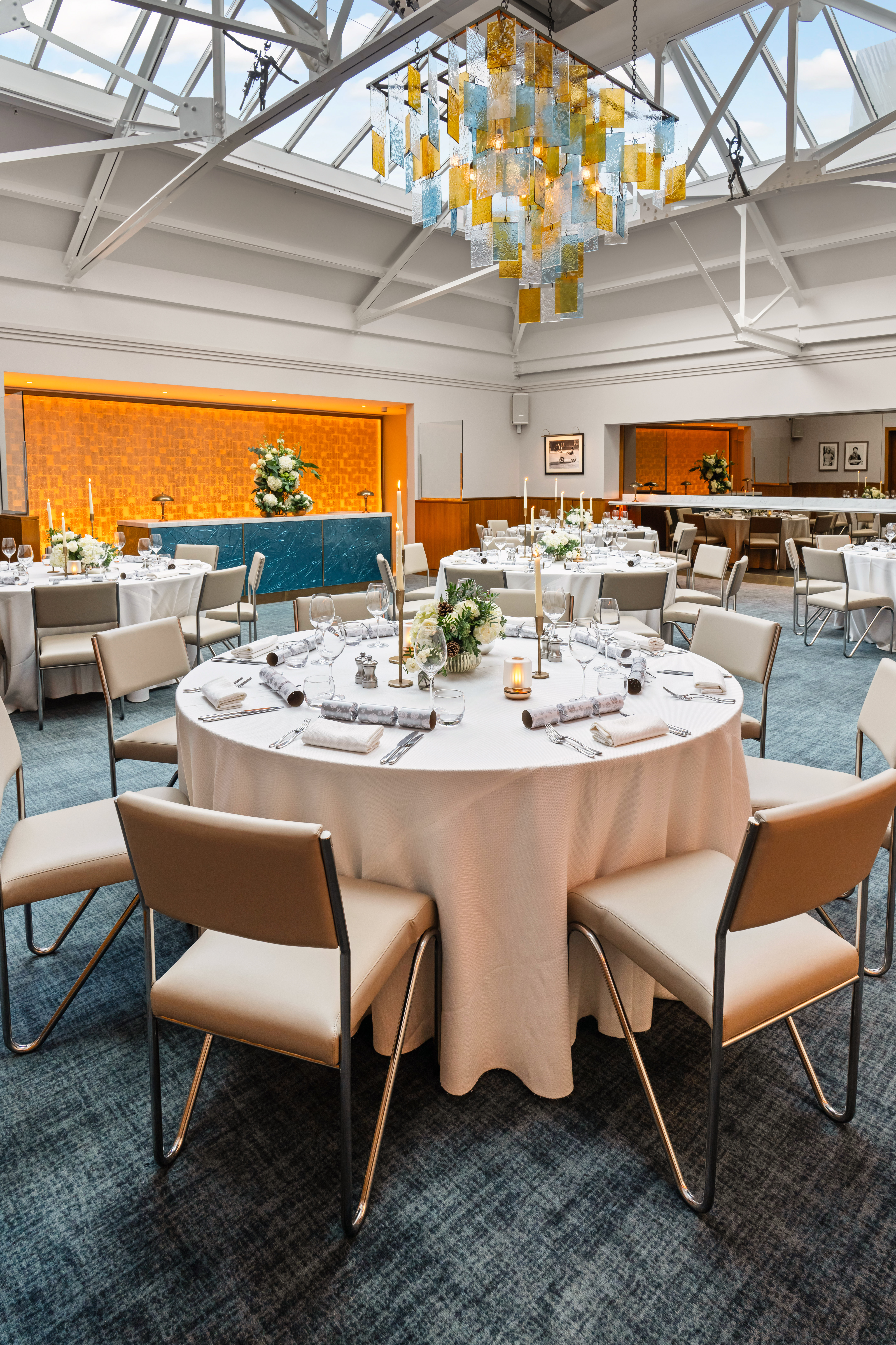 Elegant event space in Bluebird Chelsea with round tables and warm ambient lighting.