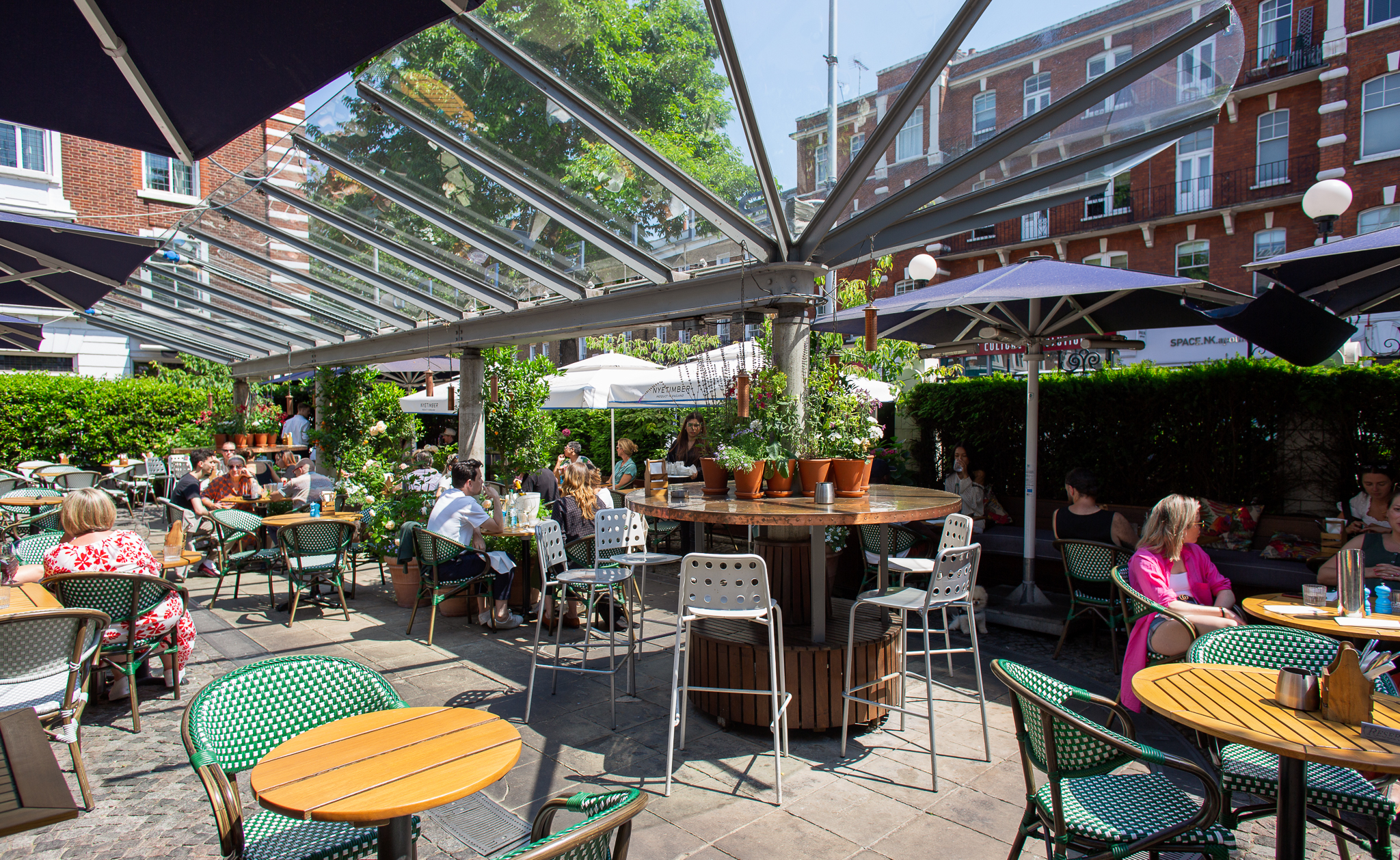 Vibrant outdoor courtyard with glass roof, ideal for casual meetings and social events.