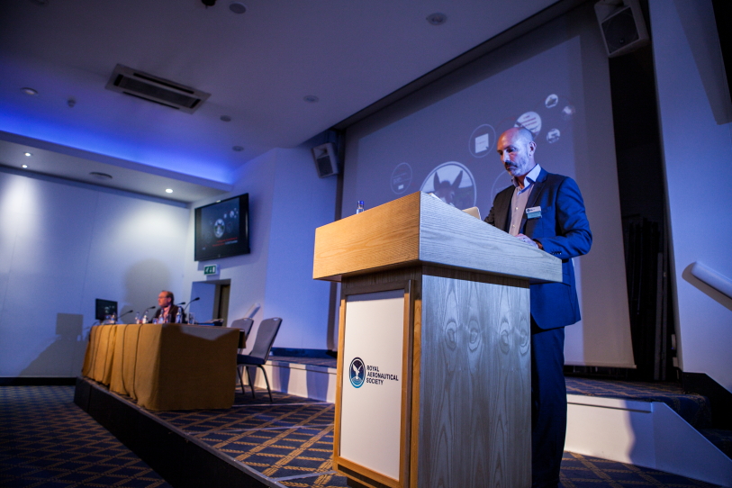 Professional speaker at podium in Bill Boeing Room during conference event.