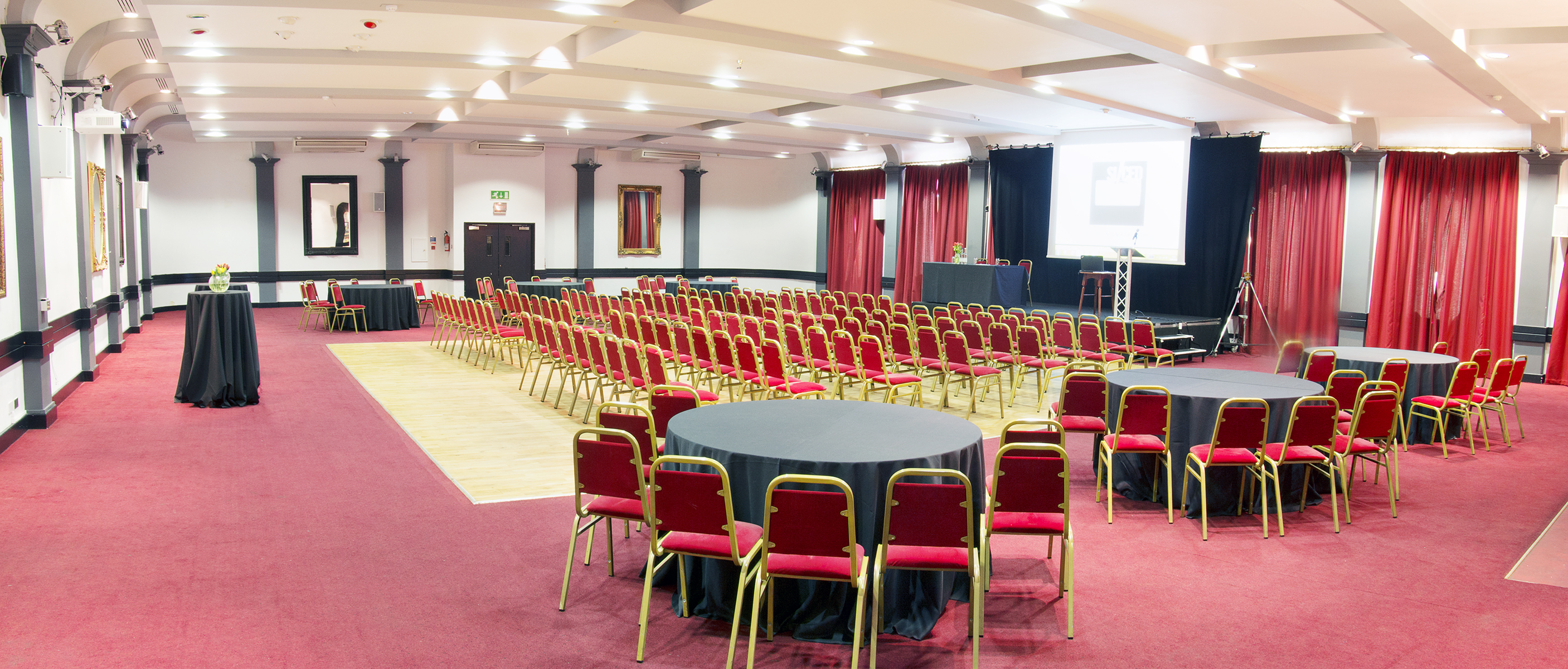 McNamara Suite at The London Irish Centre, red chairs set for a conference event.