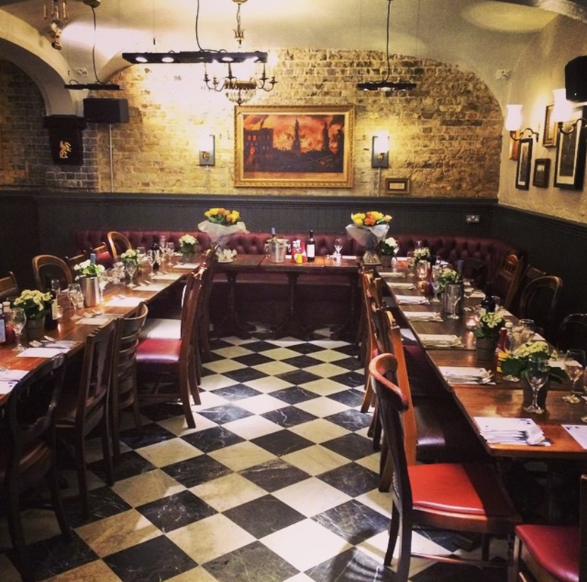 Marthas Cellar Bar dining space with floral centerpieces for events and gatherings.