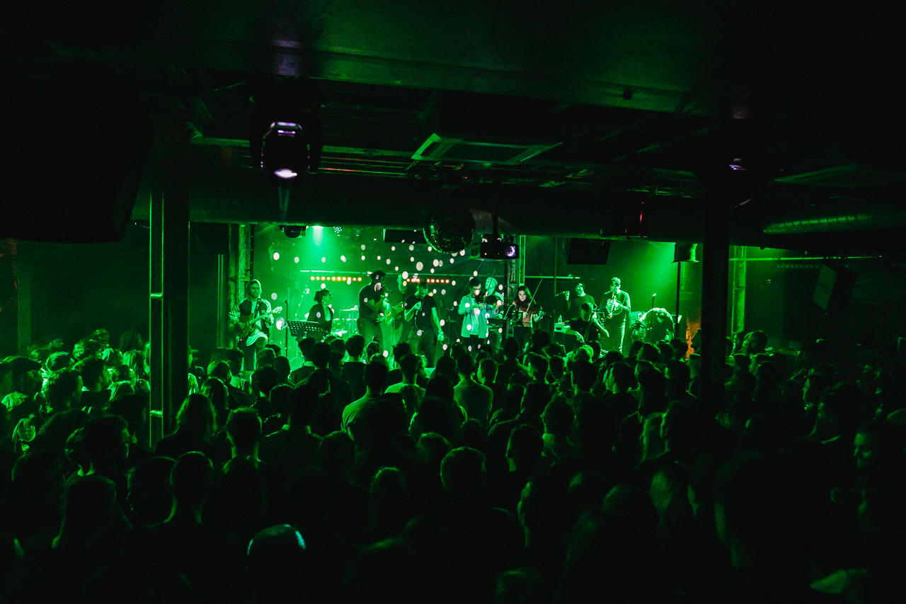 Vibrant live event at XOYO with dynamic green lighting and engaged audience.