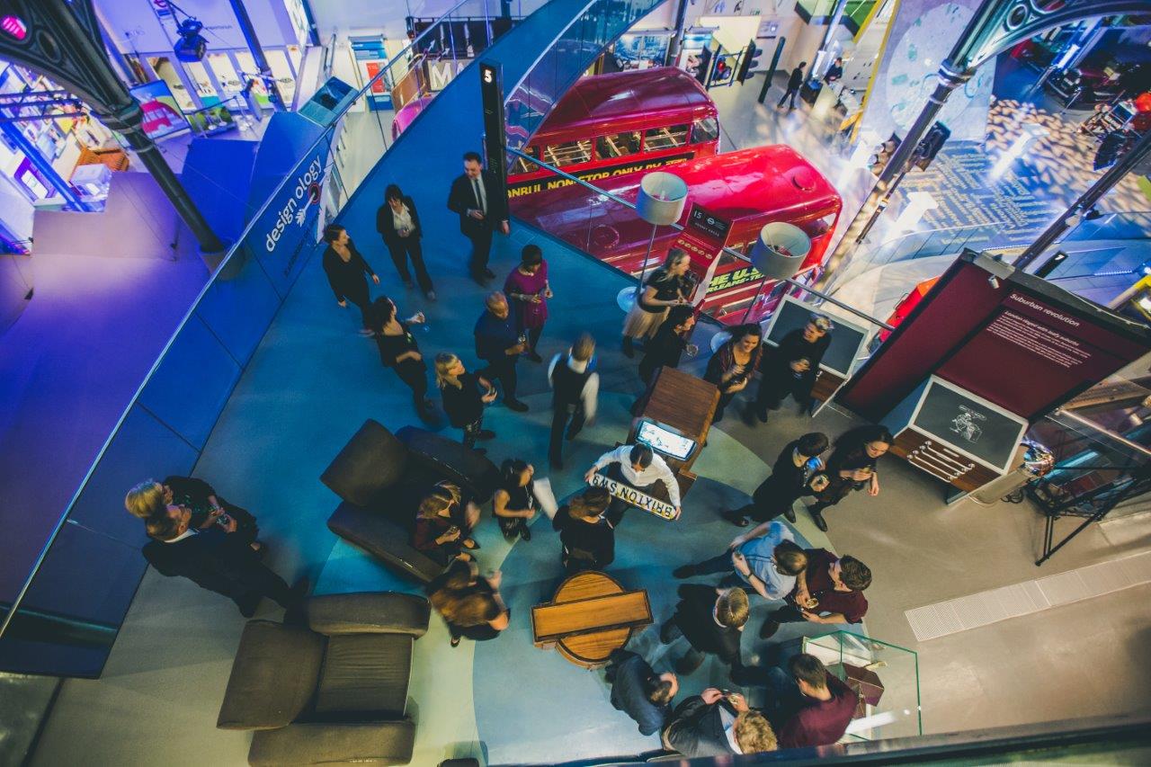 Vibrant networking event at London Transport Museum with classic red double-decker bus.