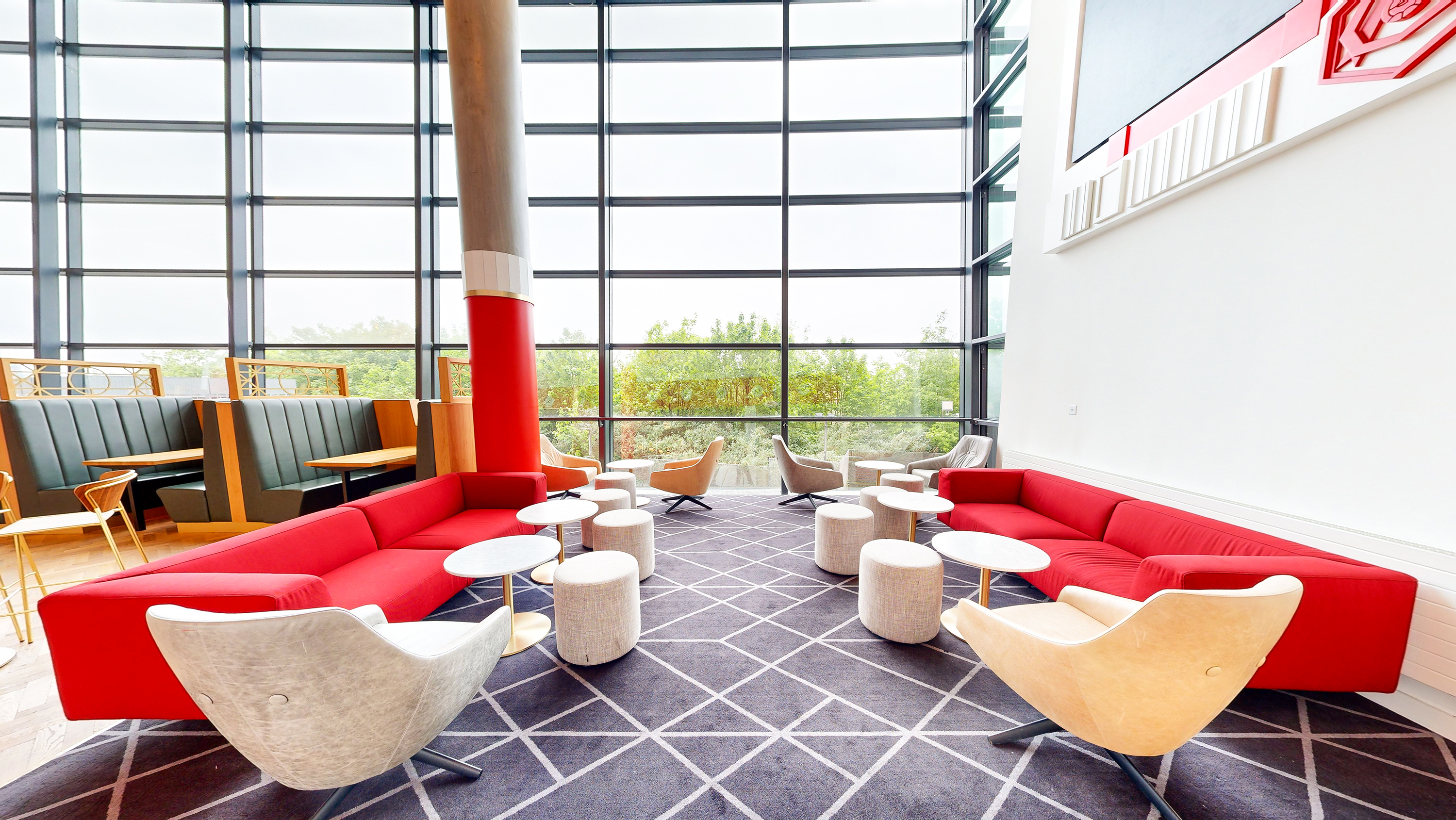 Highbury lounge at Emirates Stadium with vibrant red seating for networking events.