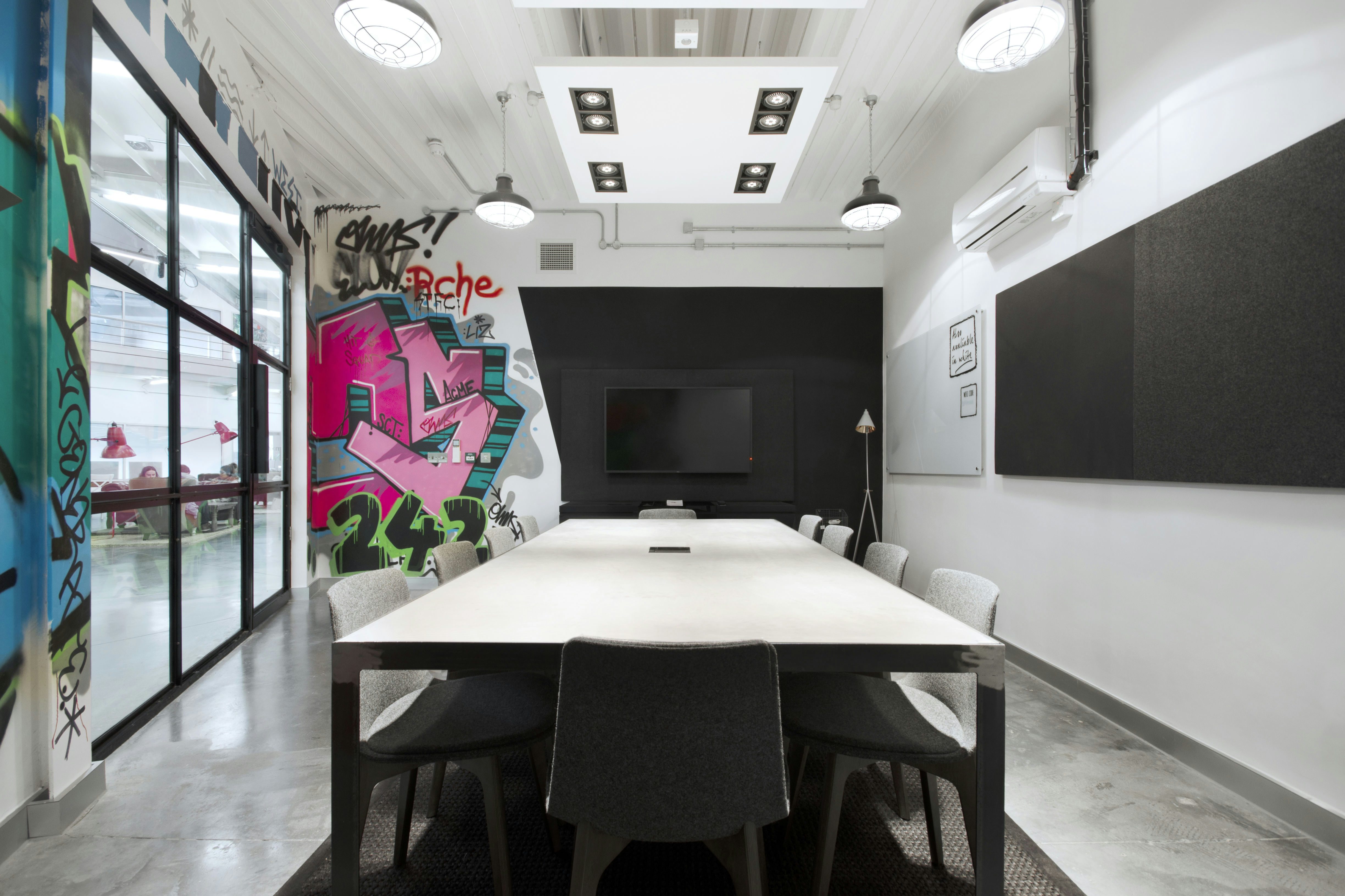 Modern meeting room with vibrant graffiti, ideal for creative workshops and brainstorming.