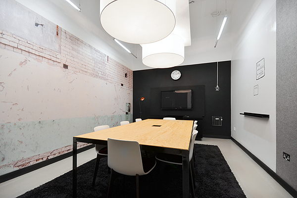 Modern meeting room with wooden table, ideal for collaborative brainstorming sessions.