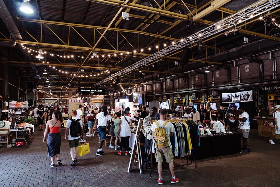 Vibrant trade show at Vanway, Printworks London with bustling attendees and warm lights.