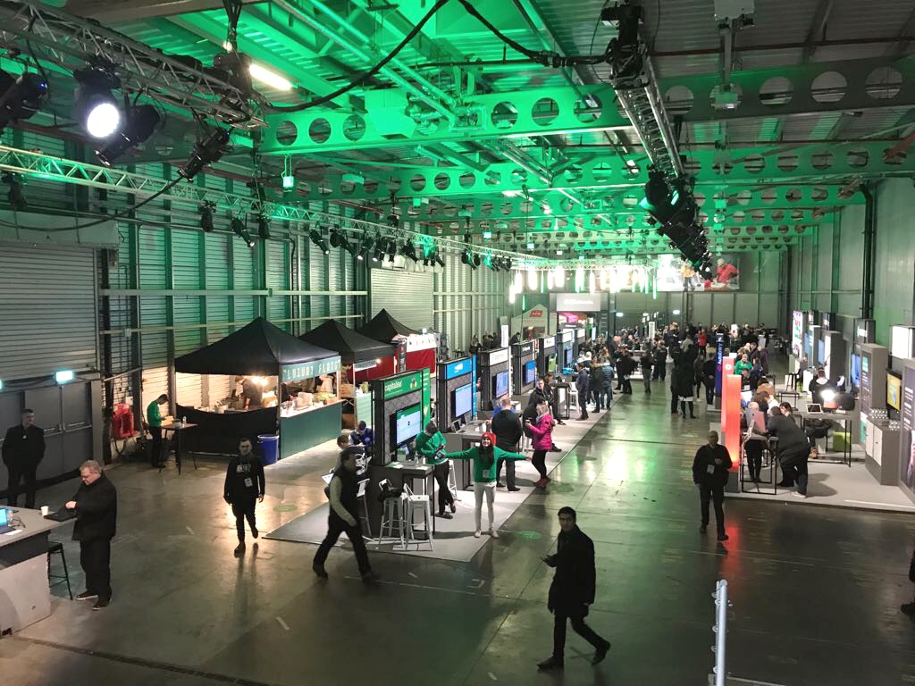 Reel Storage exhibition in Printworks London, featuring booths and green lighting for networking.